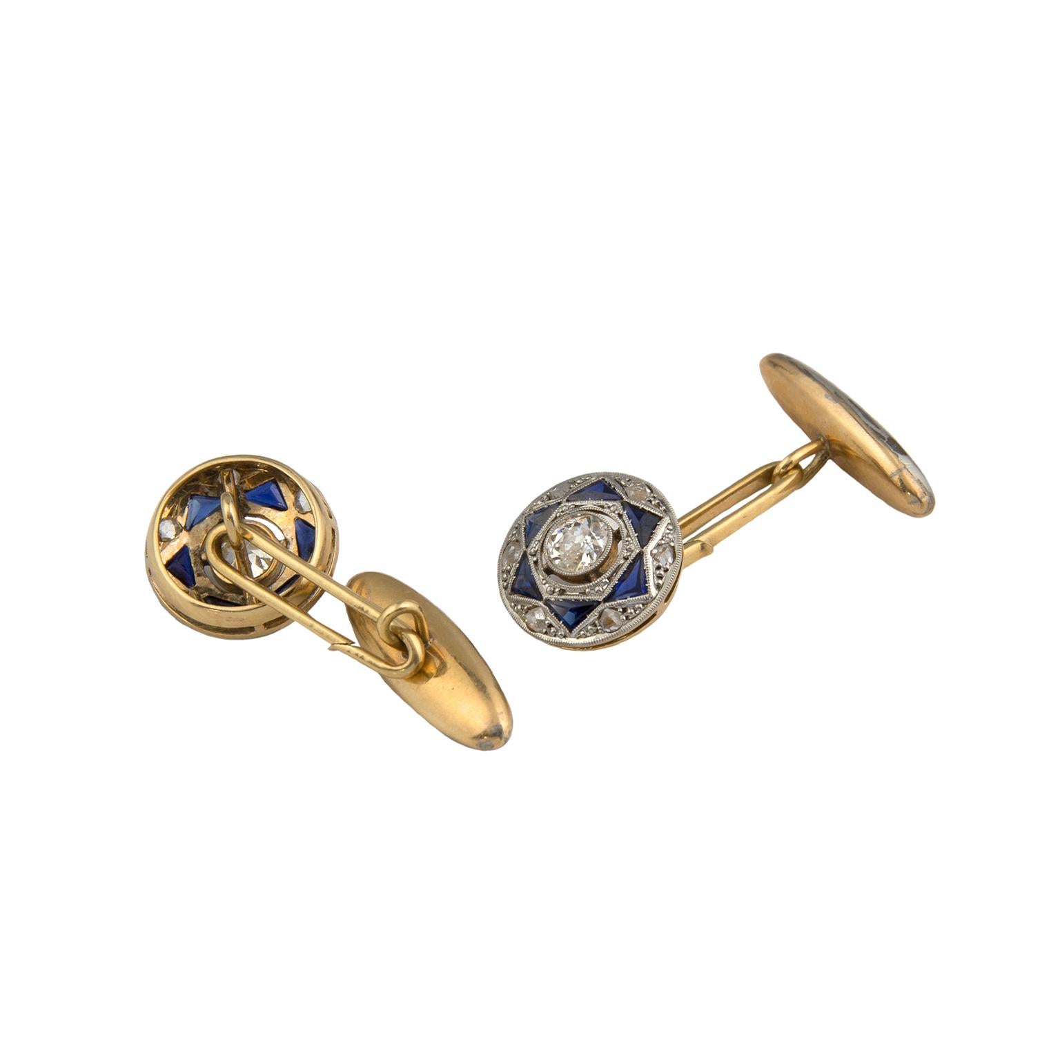 Cufflinks from the first half of the 20th century, in platinum-topped 18 Karat gold, set with two 0.25 carats old european cut diamonds, surrounded by 12 triangular cut blue stones and 12 rose cut diamonds, totalling 0.10 carats in weight.