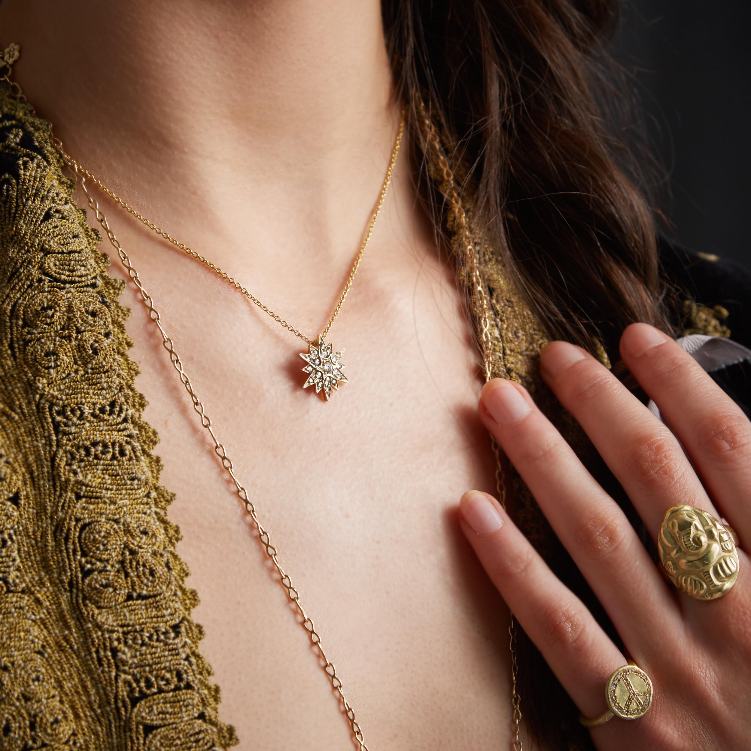 17 Diamanten mit abgestuften Rauten, gefasst in einem atemberaubenden Stern aus 18 Karat Gold mit 12 Spitzen. Der Anhänger hat eine dezente Schlaufe auf der Rückseite des Anhängers, durch die die Kette gefädelt wird. Dieser Anhänger hängt an einer