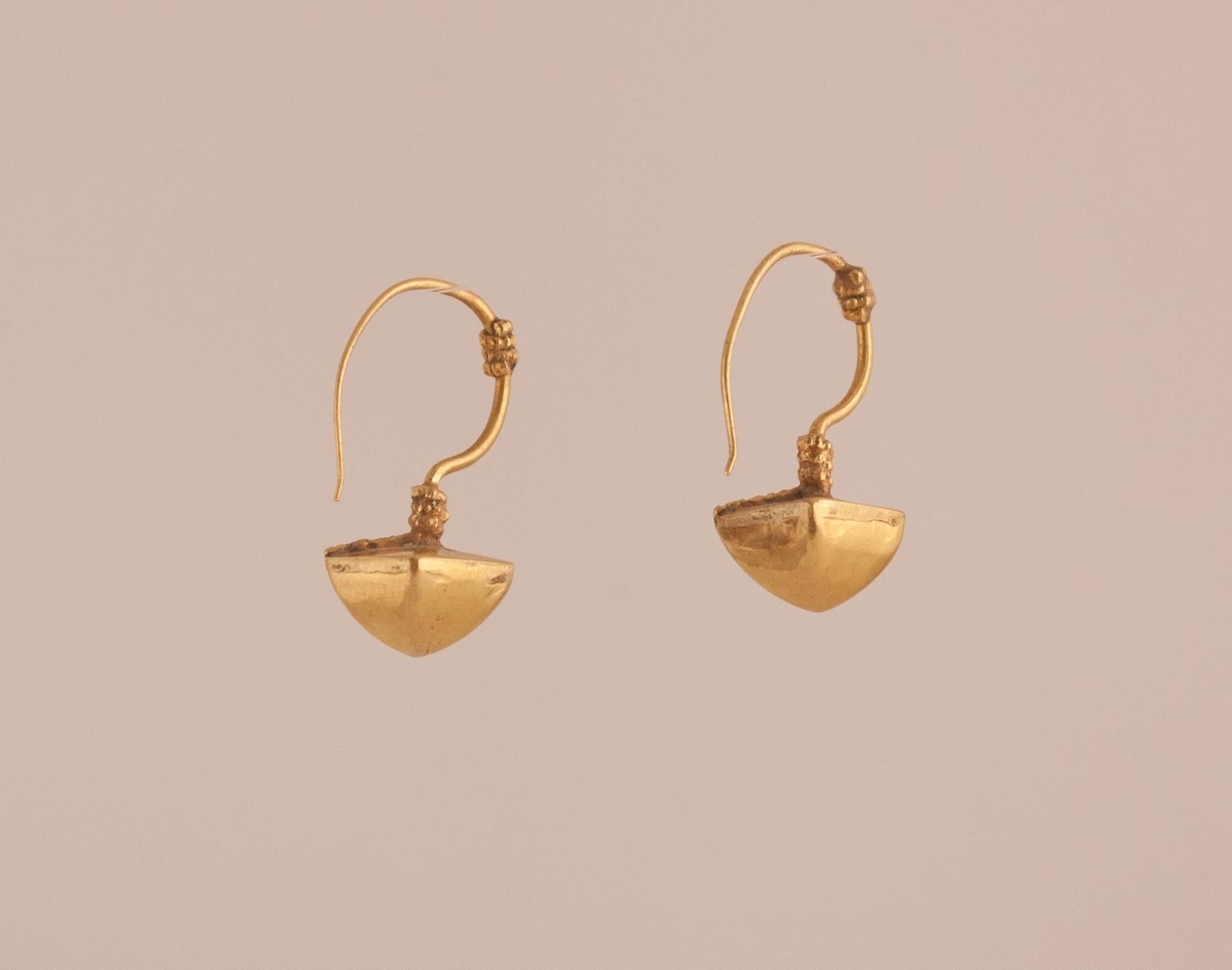 A pair of 18 karat gold pyramid-shaped earrings handcrafted in India, circa 1950. Tasteful granulation work on the fixed wire and flat top add interest to these three-dimensional tribal earrings.
Gold: 7.3 grams 