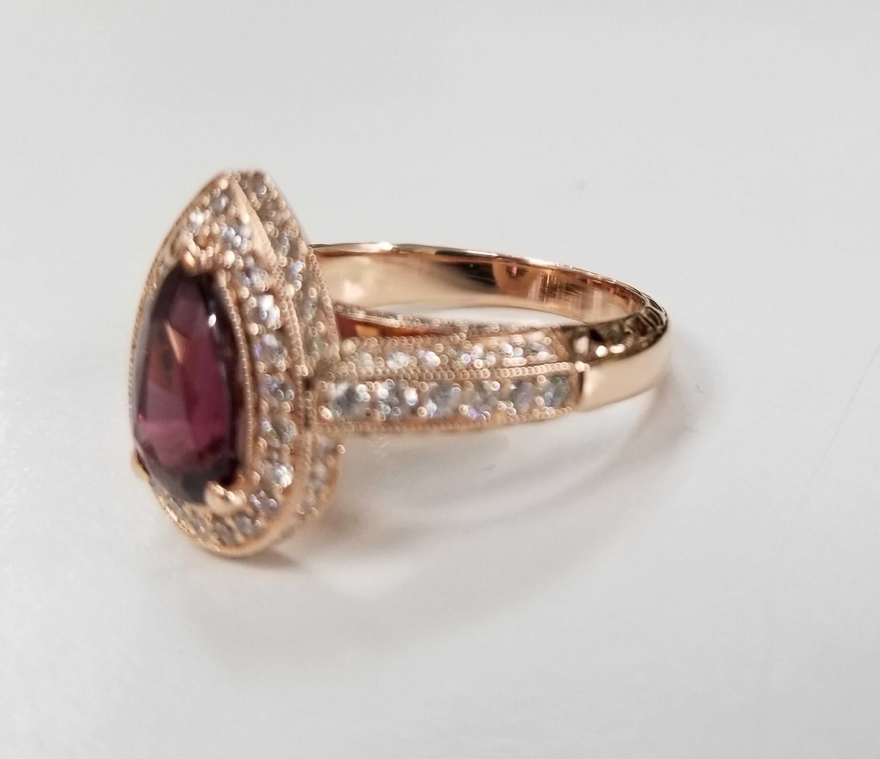 18k rose gold Rhodolite Garnet and diamond halo beaded ring, containing 1 pear shape Rhodolite Garnet of gem quality weighing 2.20cts.  Surrounded by 90 round full cut diamonds; color 