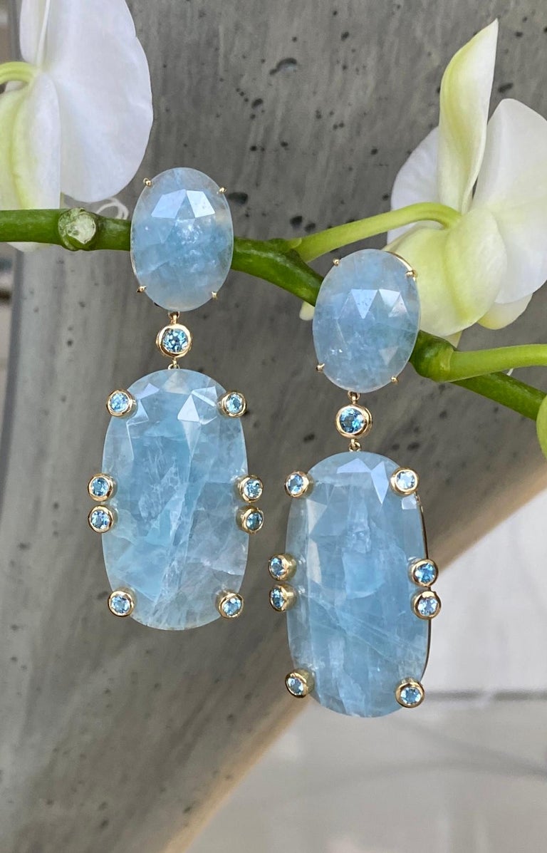 Rose-cut aquamarine and blue topaz accented drop dangle earrings, handcrafted in 18K yellow gold.

These luxurious one-of-a-kind aquamarine earrings are accented with vibrant blue topaz to create a gorgeous palette of blue shades. They make a