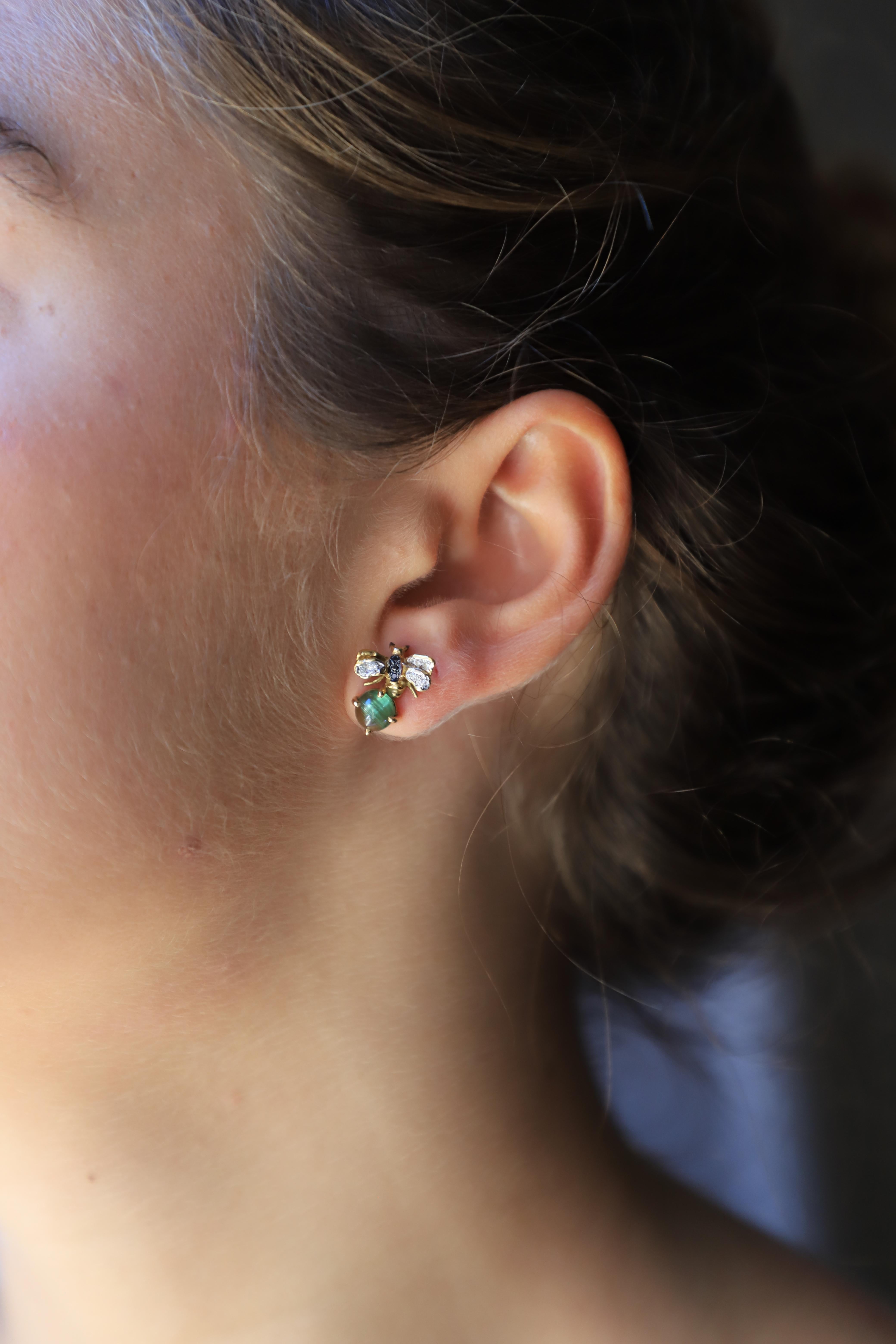 Rossella Ugolini Design Collection, a pair of Little Bees Stud Earrings handcrafted in 18 Karats Yellow Gold and adorned with a beautiful green Tourmaline stone, 0.10 carats White Diamonds and 0.06 karats deep Black Diamonds. 
Dimensions: 0.06 in.