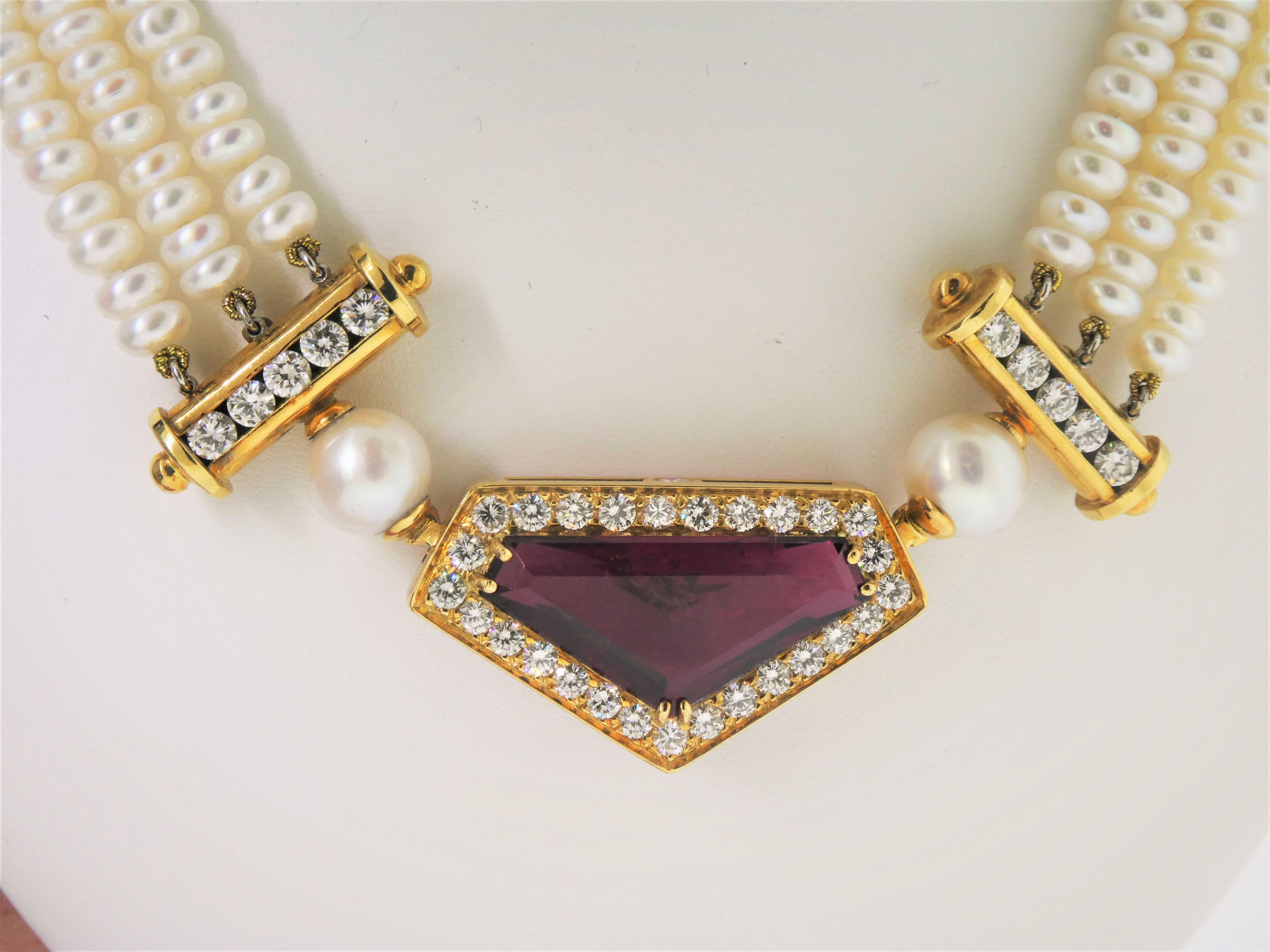 Sitting in an 18 karat gold mounting, surrounded by a row of diamonds (1.38 carats), this pendant sits on three strands of button pearls joined by diamond bars (1.10 carats) on either side.  Designed by Michael Engelhardt,  the necklace contains an