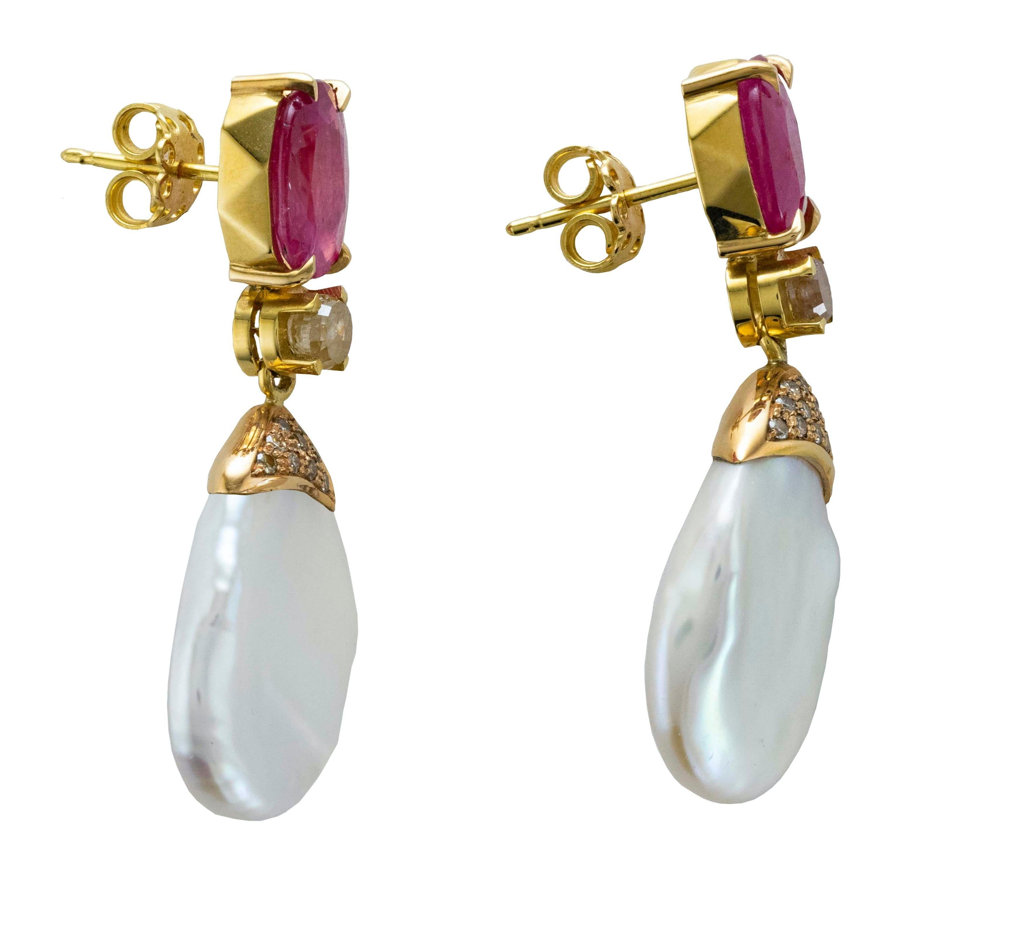 18 Karat yellow gold drop earrings made up from irregular shape pearls which catch the light and reflect it in various colors, from pink to green.
They are settled from two oval cut Rubies and embellished from two Old cut brown Diamonds.
Thy light