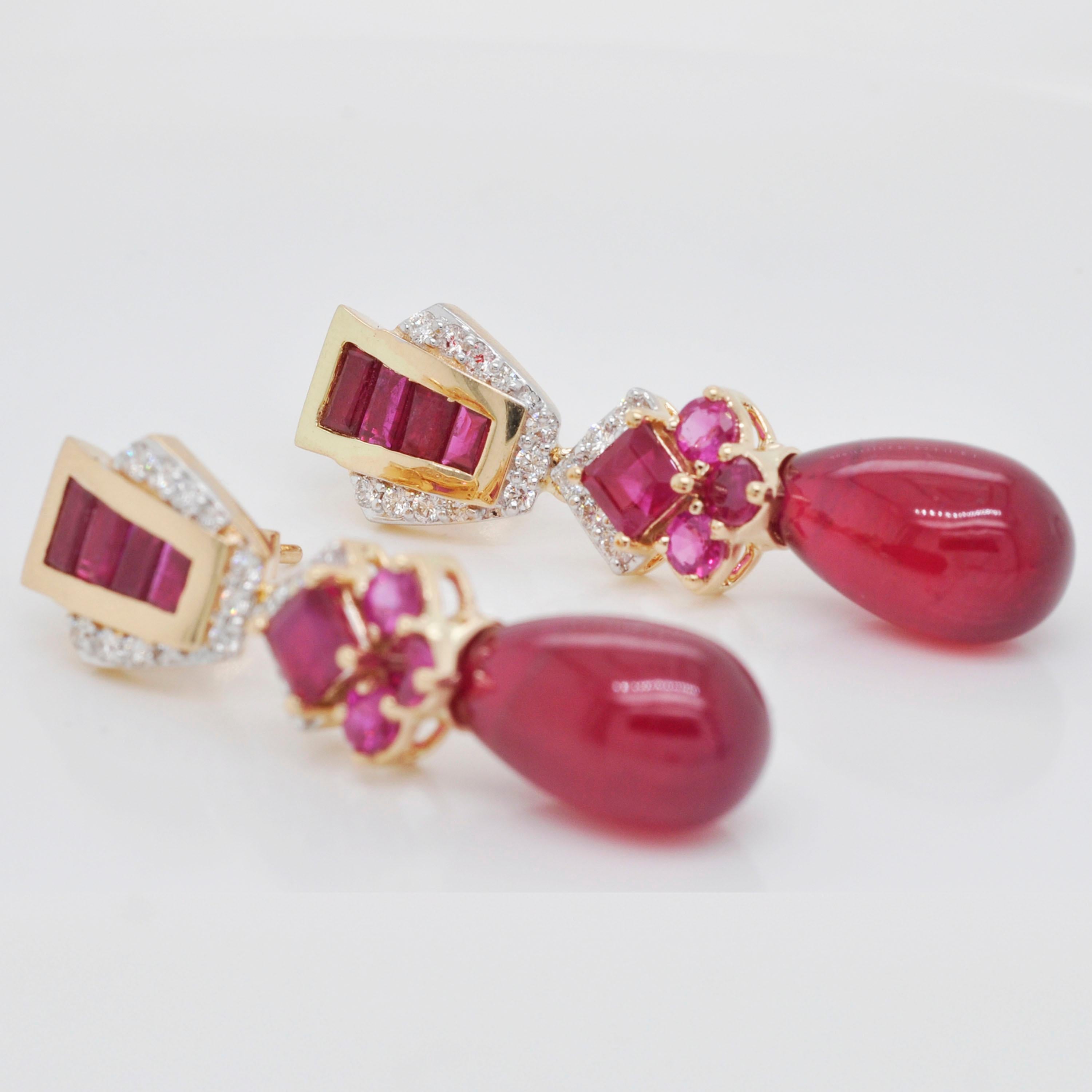 18 karat gold ruby baguette ruby drop diamond dangle earrings.

This adorable and glamorous crimson red ruby and drop earring is splendid. The formation of baguettes, squares, rounds and drop rubies and diamonds in the side pave setting create the