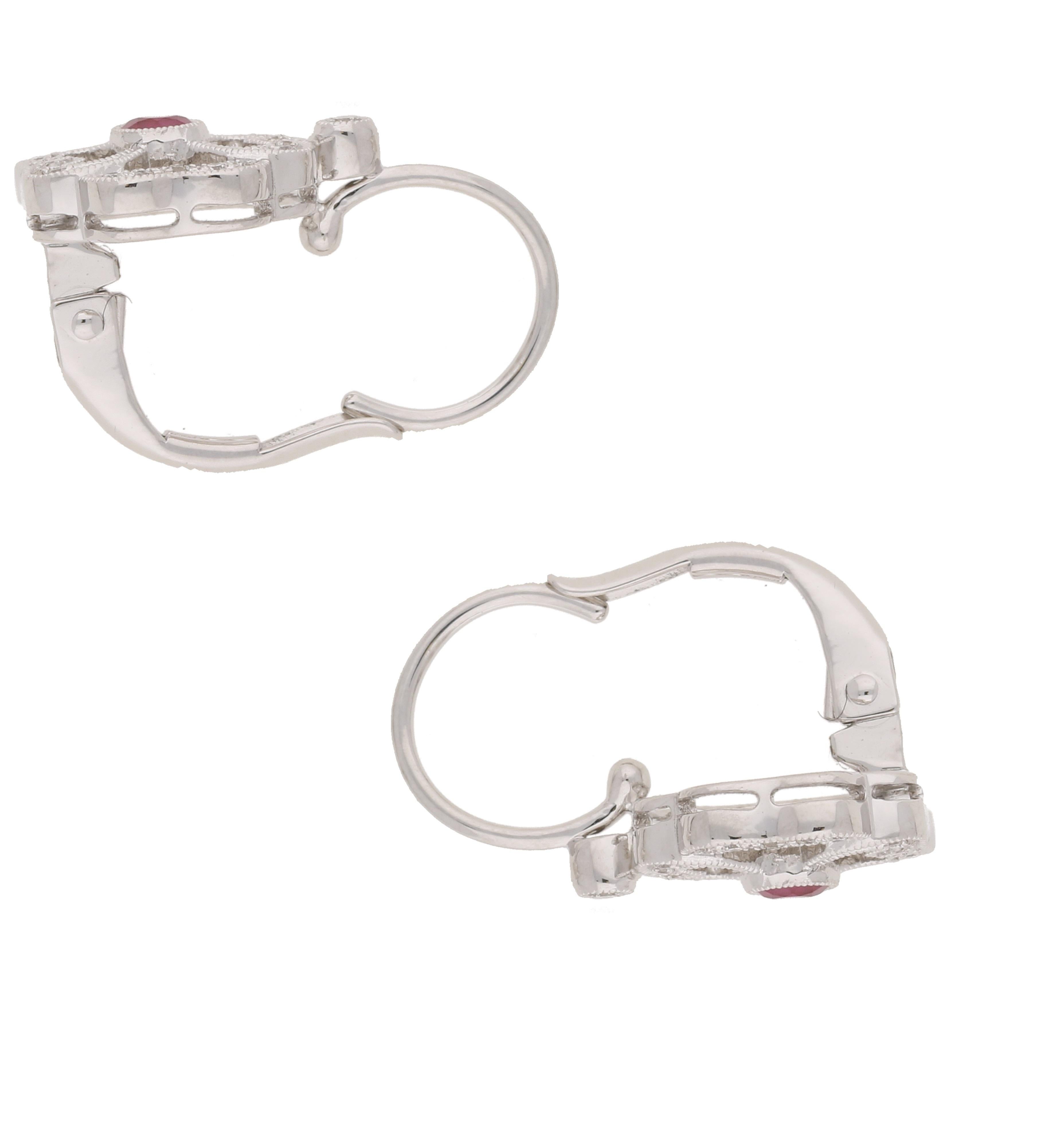 Orecchini a goccia in oro bianco 18 ct con diamanti e rubini e design vintage a trifoglio. Gli orecchini presentano un rubino rotondo sfaccettato incastonato al centro con diamanti incastonati a grani nel contorno e un singolo diamante rotondo