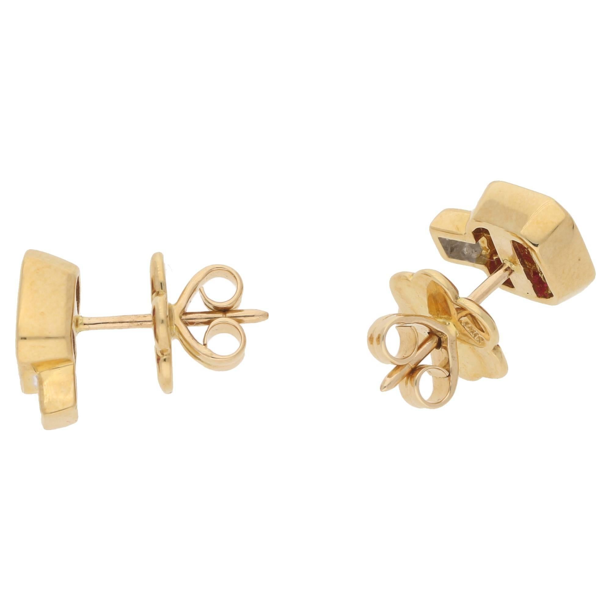 A chic pair of invisibly set ruby and diamond stud earrings in 18ct yellow gold. Consisting of nine French cut rubies in an 18ct yellow gold rub over setting stylishly topped with a princess cut diamond in an 18ct yellow gold collet setting. On post