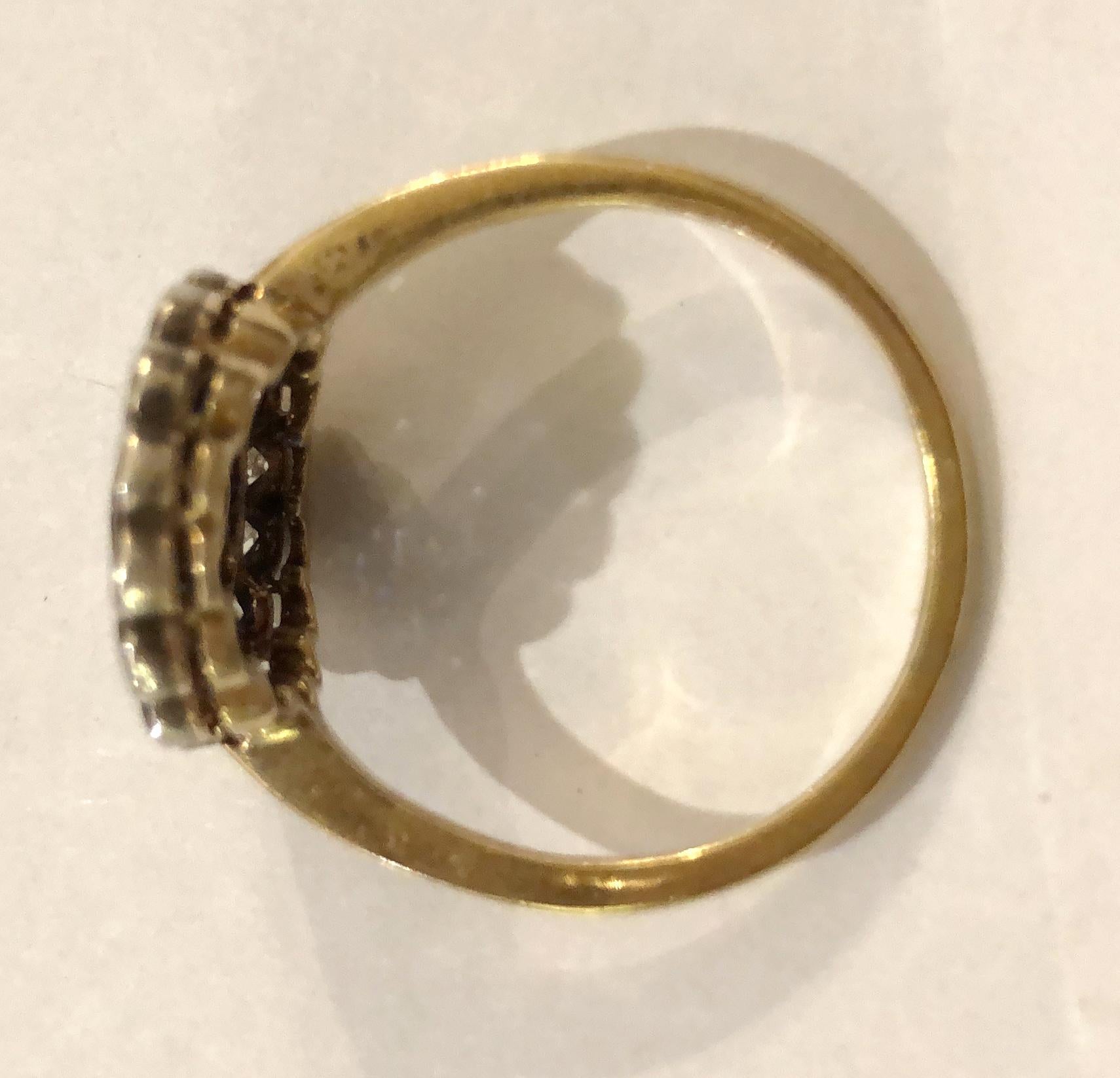 Gänseblümchenring aus 18-karätigem Gold, mit einem großen Diamanten von 0,25 Karat in der Mitte und umlaufenden Brillanten auf der Kontur von insgesamt 0,4 Karat mit Saphiren im Carre-Schliff, Italien 1920-1930er Jahre
Ringgröße US 10-10.5