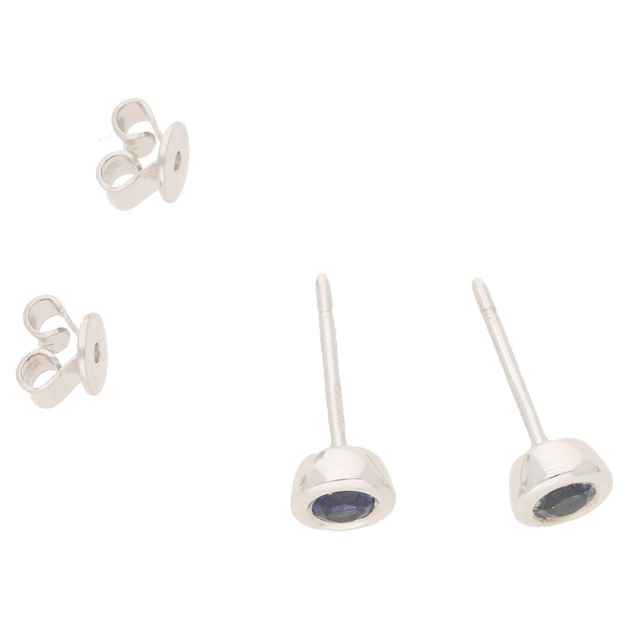 A pair of simple collet set sapphire stud earrings in 18k white gold. The sapphires total 0.36ct's and are a deep blue.The studs measure 5mm across. On post and butterfly back fittings.