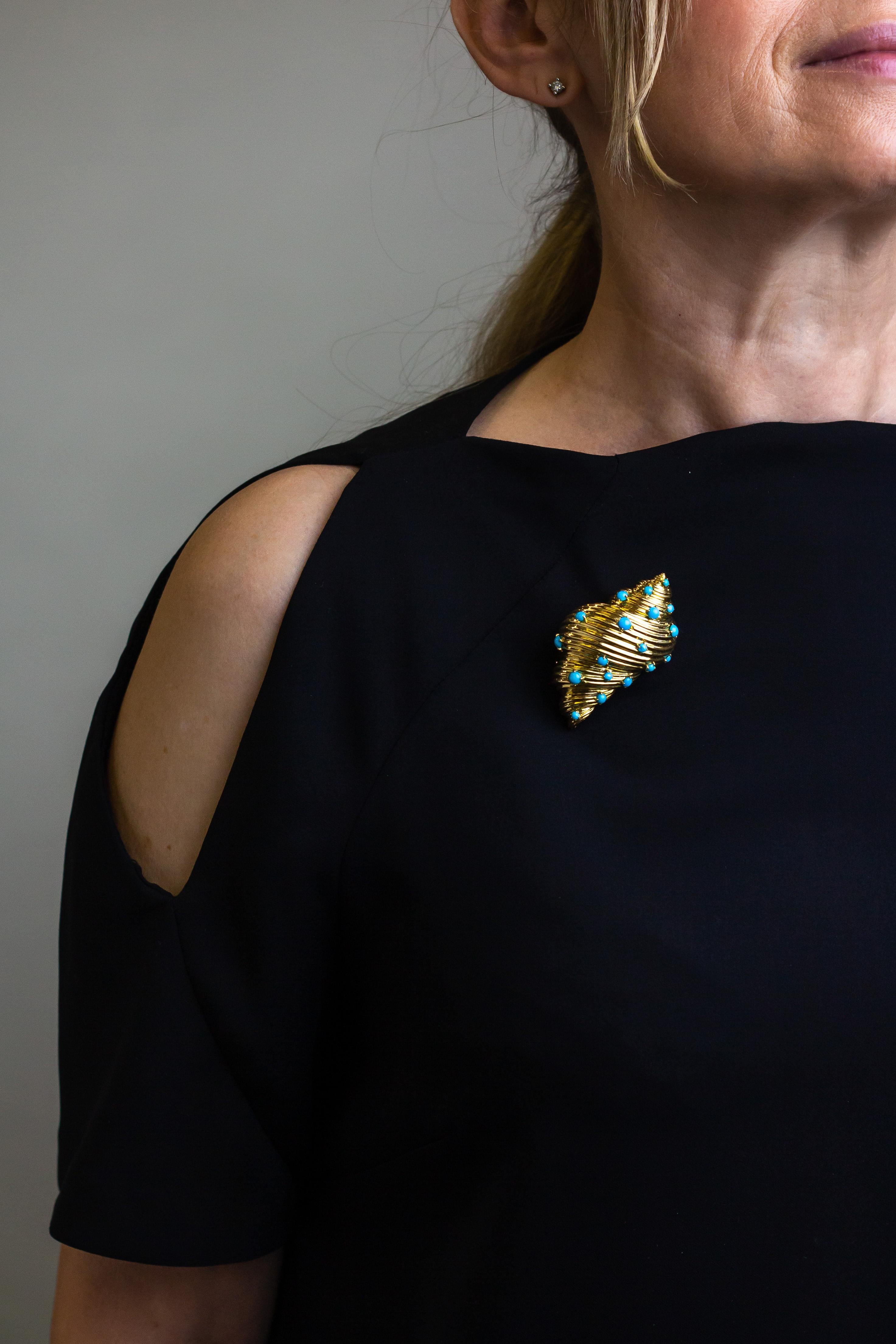 An incredible French 18 karat yellow gold shell brooch crafted by Georges L'Enfant for Tiffany & Company in France during the mid 20th century. The heavily sculpted shell is set all over with 19 round cabochon turquoise pieces which have been four