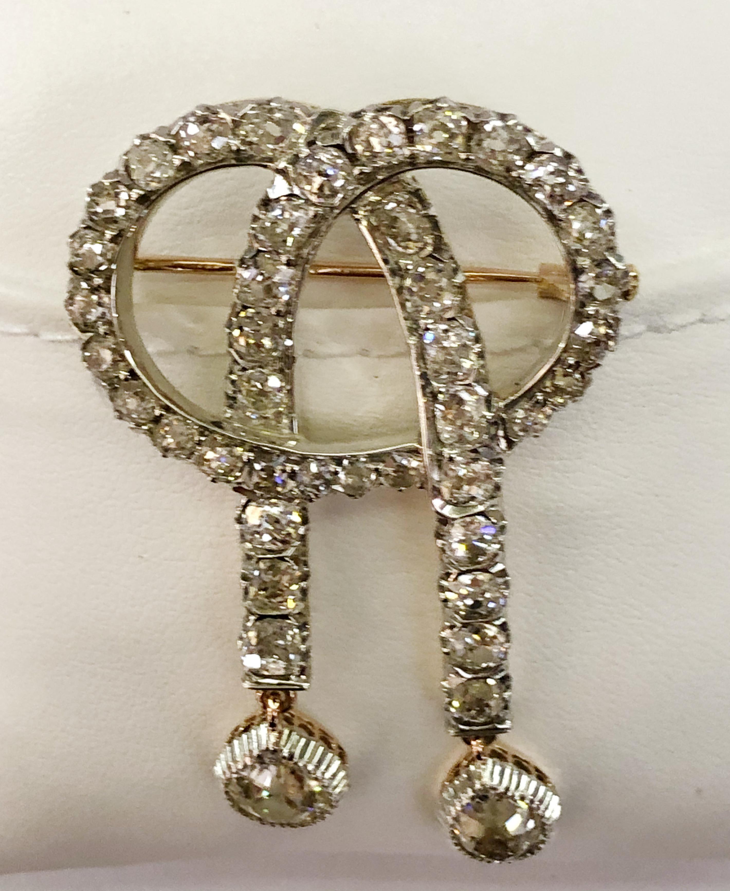 Vintage knot brooch with 18 karat yellow gold and silver, and 40 small brilliant diamonds with 2 large dangling diamonds for a total of 6 karats, Italy 1910-1930s
Length 6cm, width 3cm