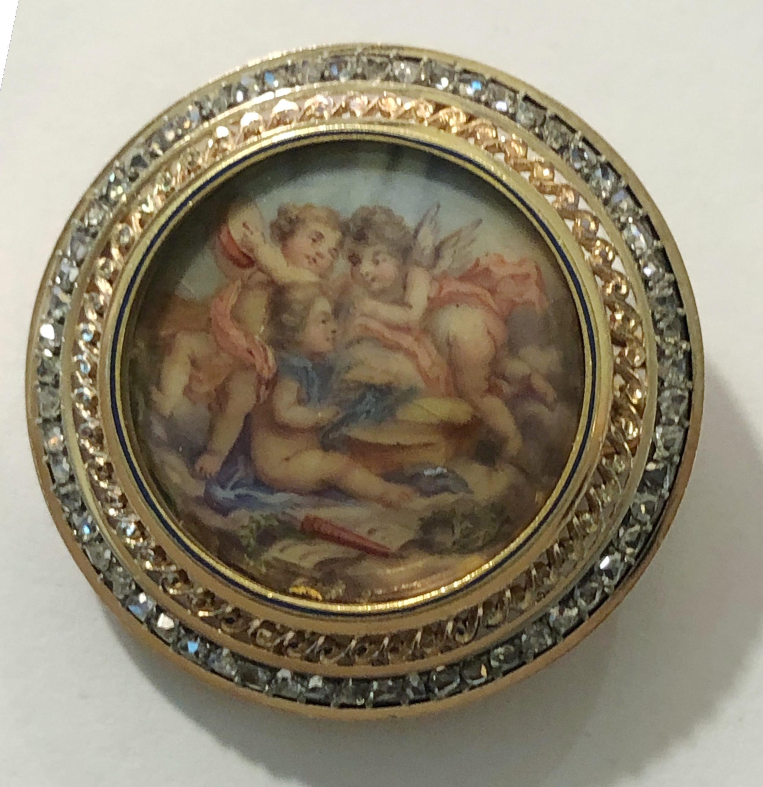 Vintage round photo holder brooch with miniatures of angels, and 18 karat gold and silver surrounded by diamonds, Italy 1920s-1930s 
Diameter 3.2cm
