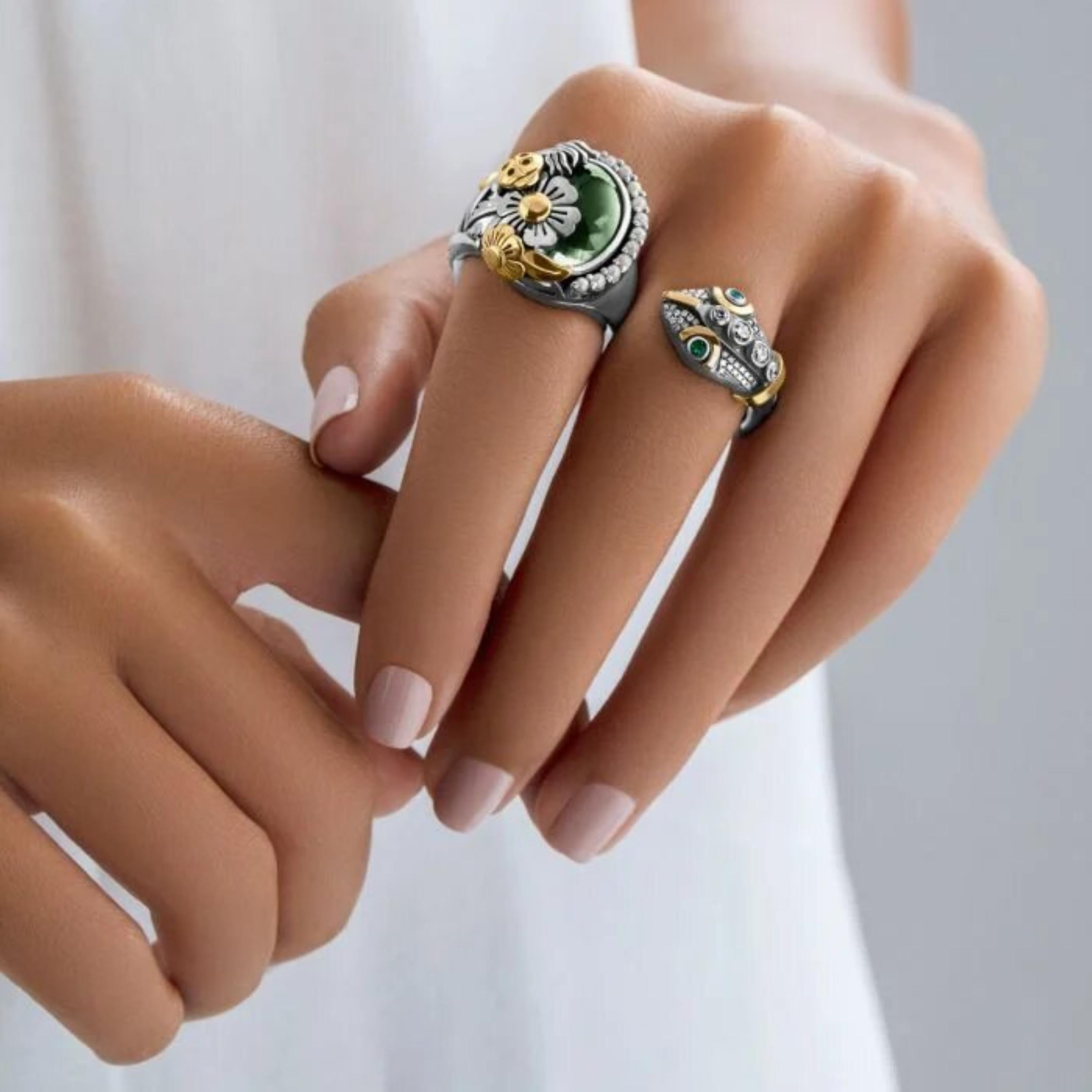 18 Karat Gold, Sterling Silver, Green Amethyst, Pearl, Diamond and Emerald Statement Snake Double Finger Ring.

18 Karat Gold and Sterling Silver Double Finger adorned with a Victorian-influenced Snake and Floral motifs, set with a 10.00 carat
