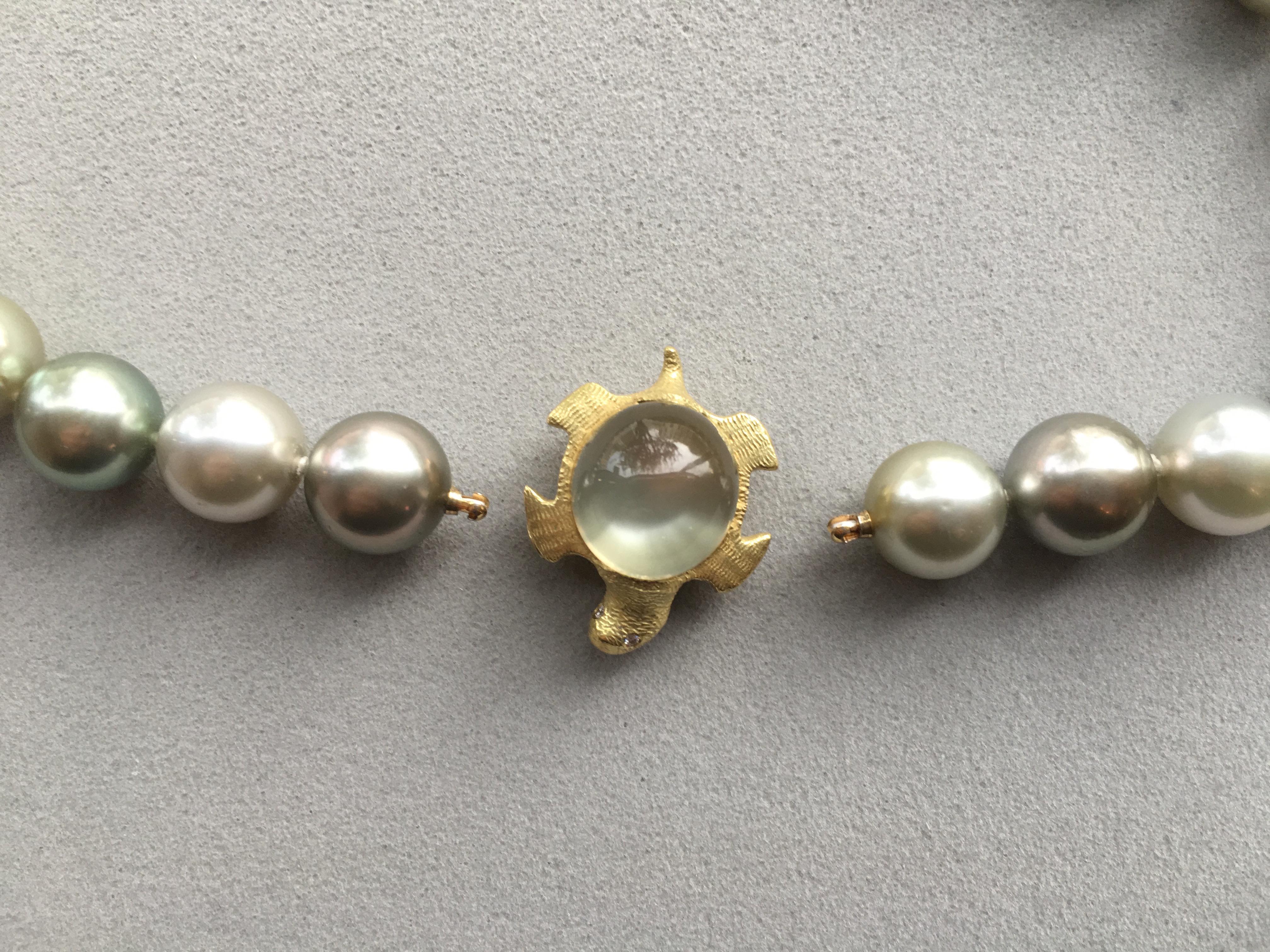 A magnificent row of pistachio multicolor Tahitian pearls with an interchangeable moonstone tortoise 18 Karat gold clasp.  

Moonstone: 17.16 cts
Pearls: 11.5mm,  AAA quality