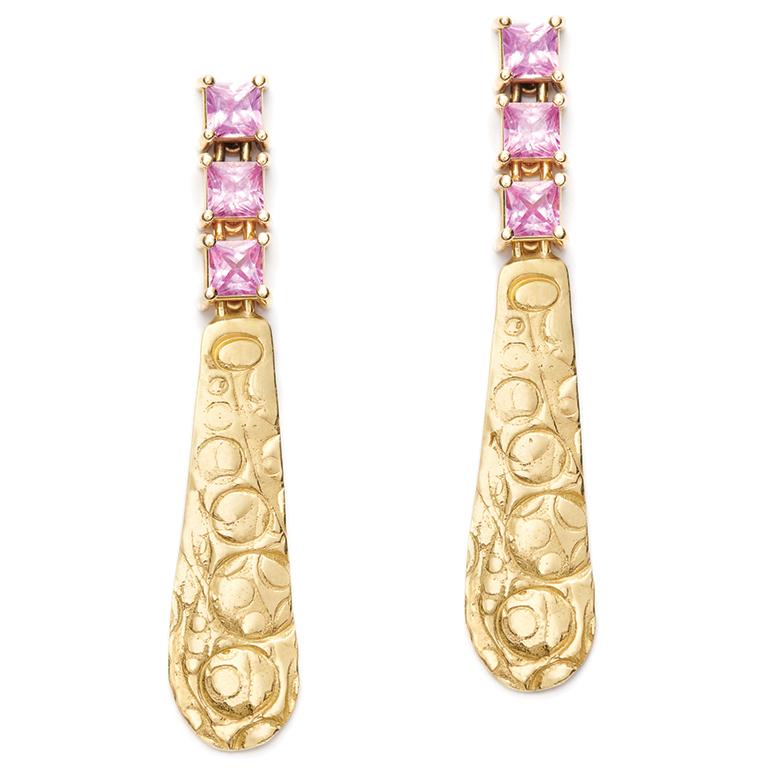 Flattering and fashion-forward, these exquisite 18 Karat Gold textured drops are suspended from a trio of square cut Pink Sapphires (2 Carat). Post and clutch backs.

Pink Sapphire: 5 mm wide x 5 mm high