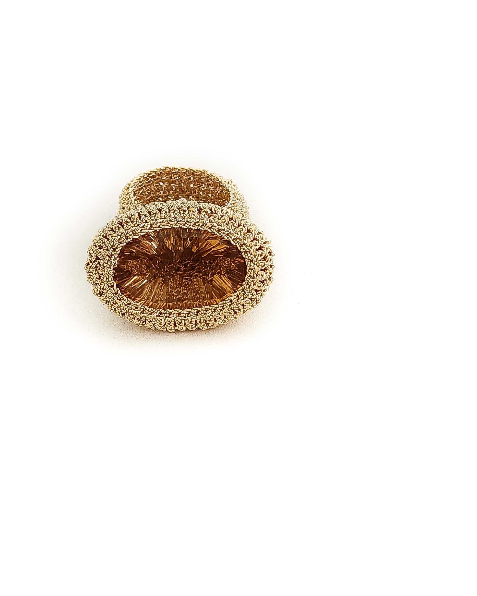 Beautiful, one of a kind crochet ring. It is meticulously handcrafted with 18 karat gold thread. The thread is made of an 18 karat gold wire which is flattened and wrapped around a cotton thread. The stone is a beautiful dark golden oval shaped,
