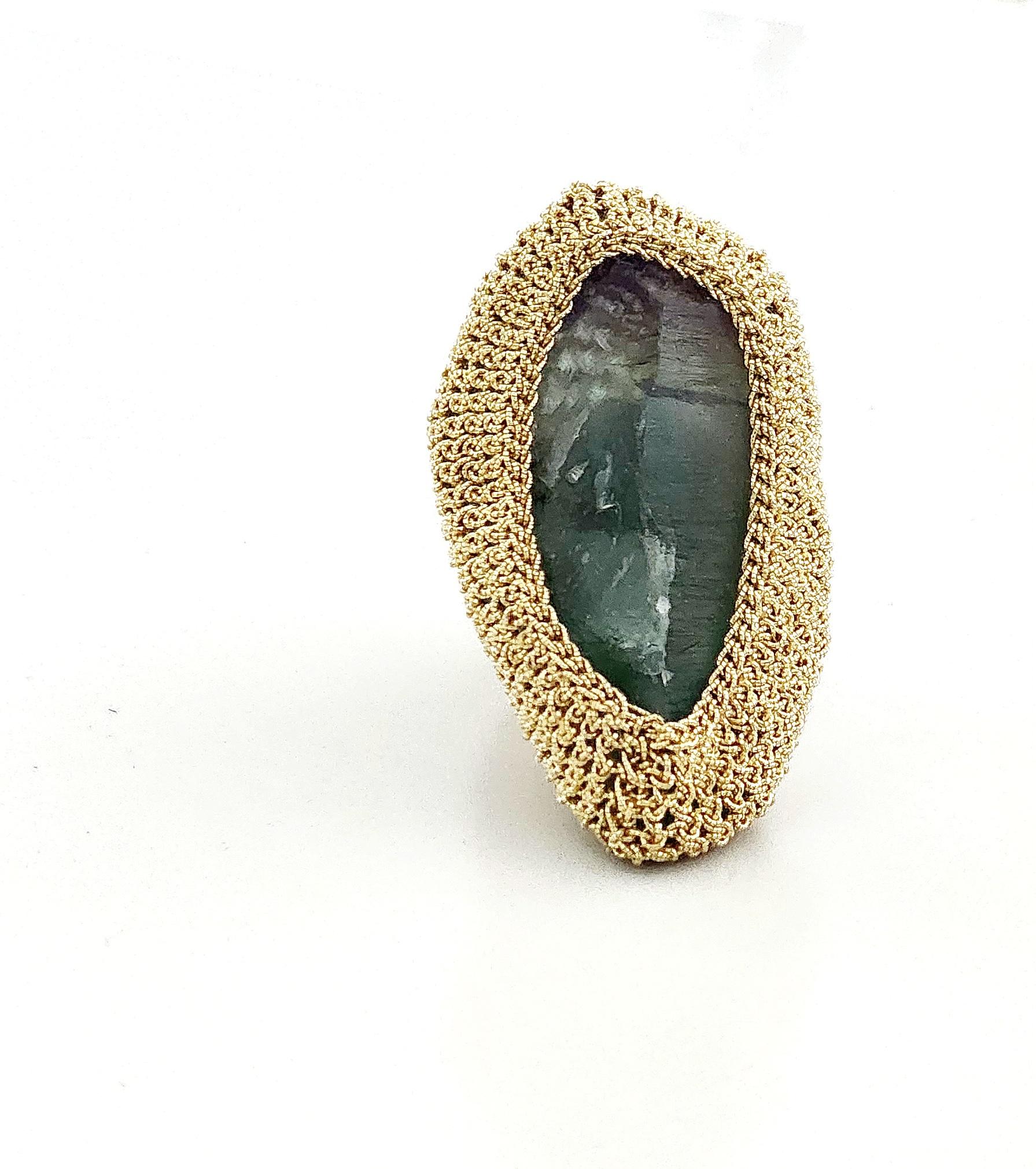 Beautiful, one of a kind crochet ring. It is meticulously handcrafted with 18 karat gold thread. The thread is made of an 18 karat gold wire which is flattened and wrapped around a cotton core. The stone is a beautiful rough cut Fluorite.  