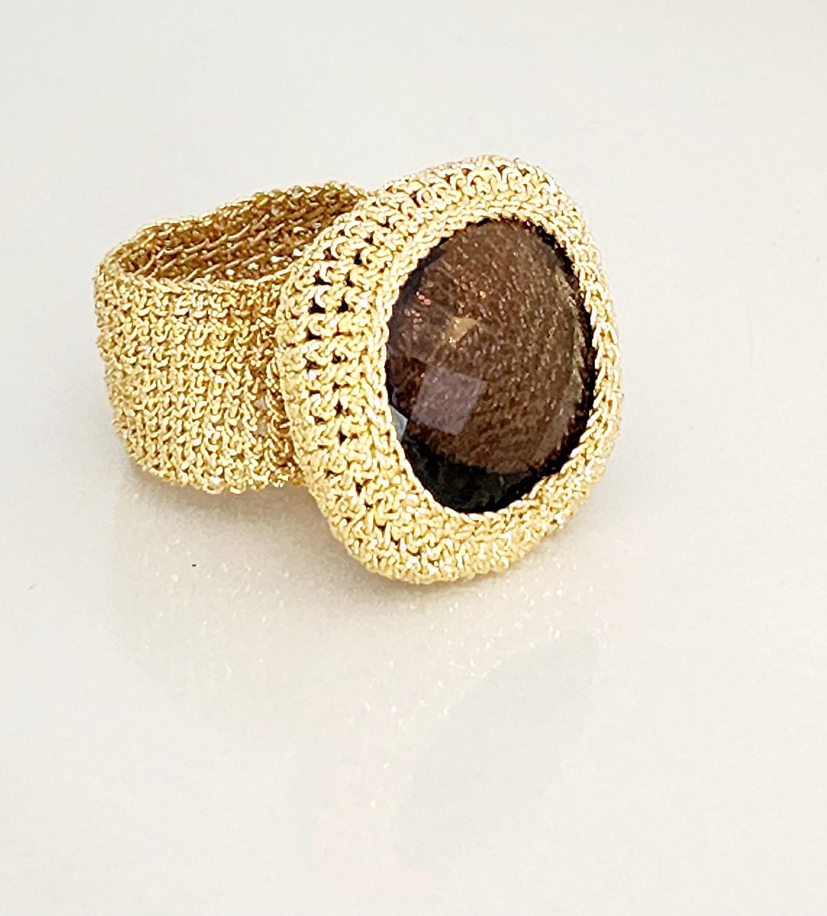 A one of a kind hand crochet ring. This beautiful ring is crochet with 18 karat gold thread. The thread is made from an 18 karat gold wire, flattened and wrapped around a cotton core. The stone is a lovely 25mmx25mm Smokey Quartz. 
Smokey Quartz is