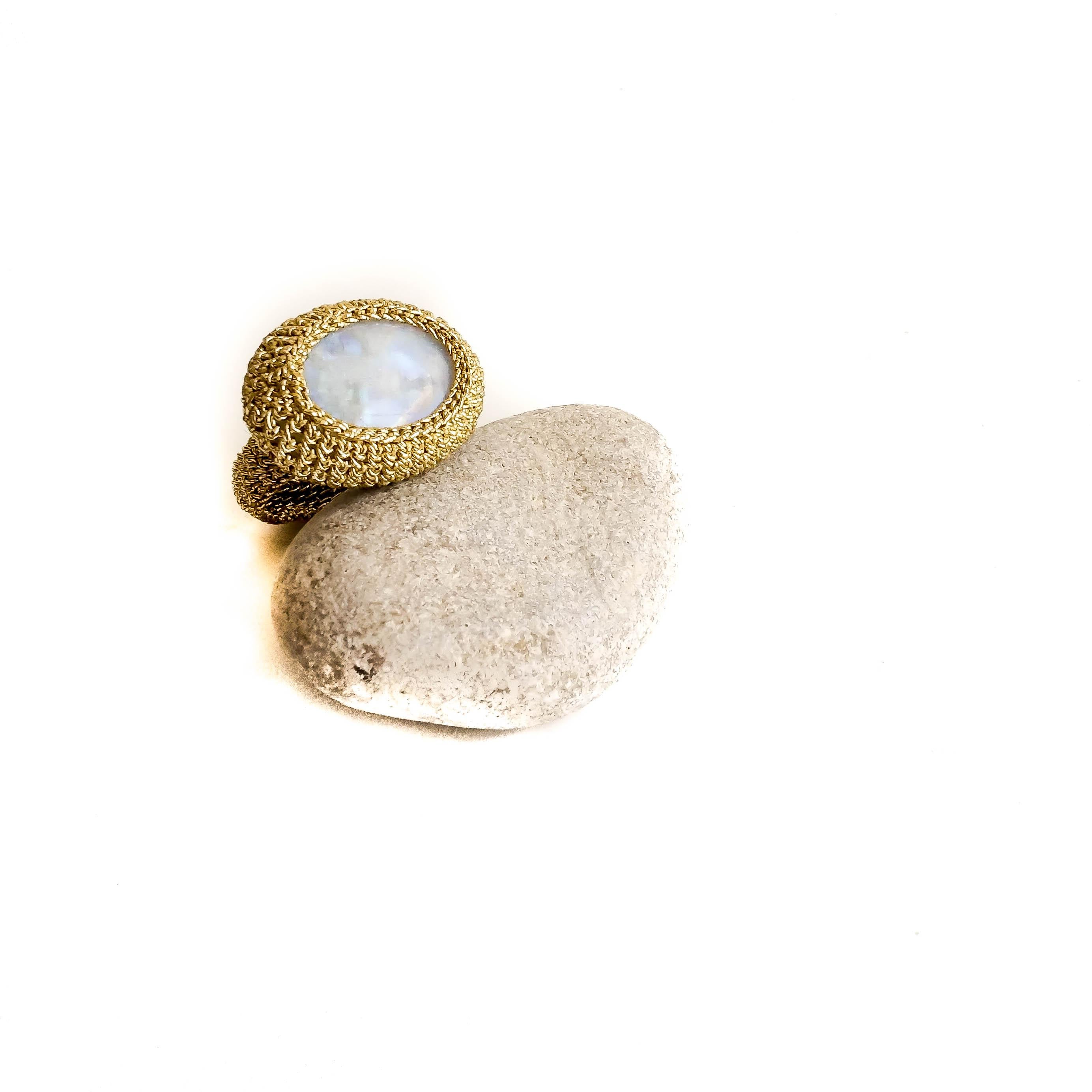 This ring is a real eye catcher. 18 Karat gold thread tightly crochet around a beautiful Moonstone.

The thread is 18 Karat gold. It is pure 18 Karat gold wire, flattend and wrapped around a cotton core. Moonstone holds the power of mystery. Pearly