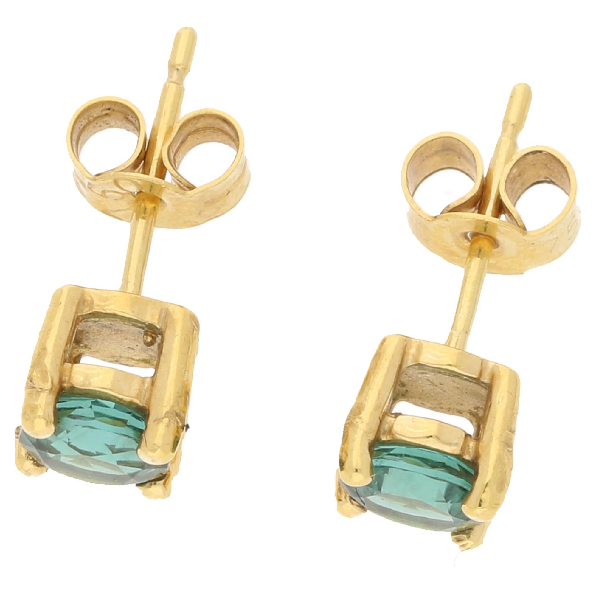 A pair of classic and elegant stud earrings set with a rich green tone of tourmaline. 
Each stone measuring approximately 0.42 carats; set in a four claw 18ct yellow gold basket setting. 
Secured with posts and butterfly backs.