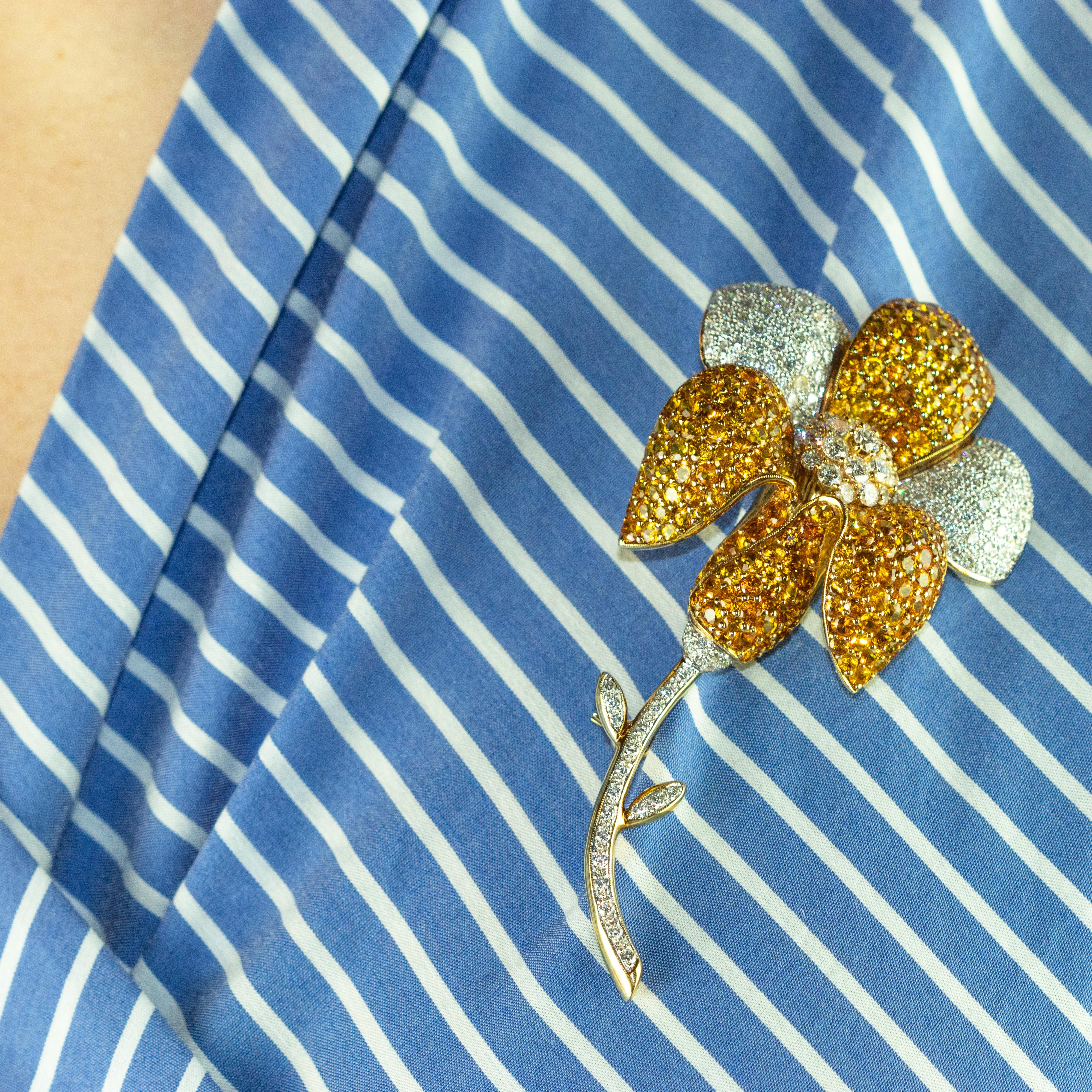 Magnificent sparkling vintage flower-shaped brooch embellished with yellow sapphires  consist of a myriad of smaller precious stones.

This jewelry is inspired by the mystical magic of nature. Flowers have been used as representations of gods and