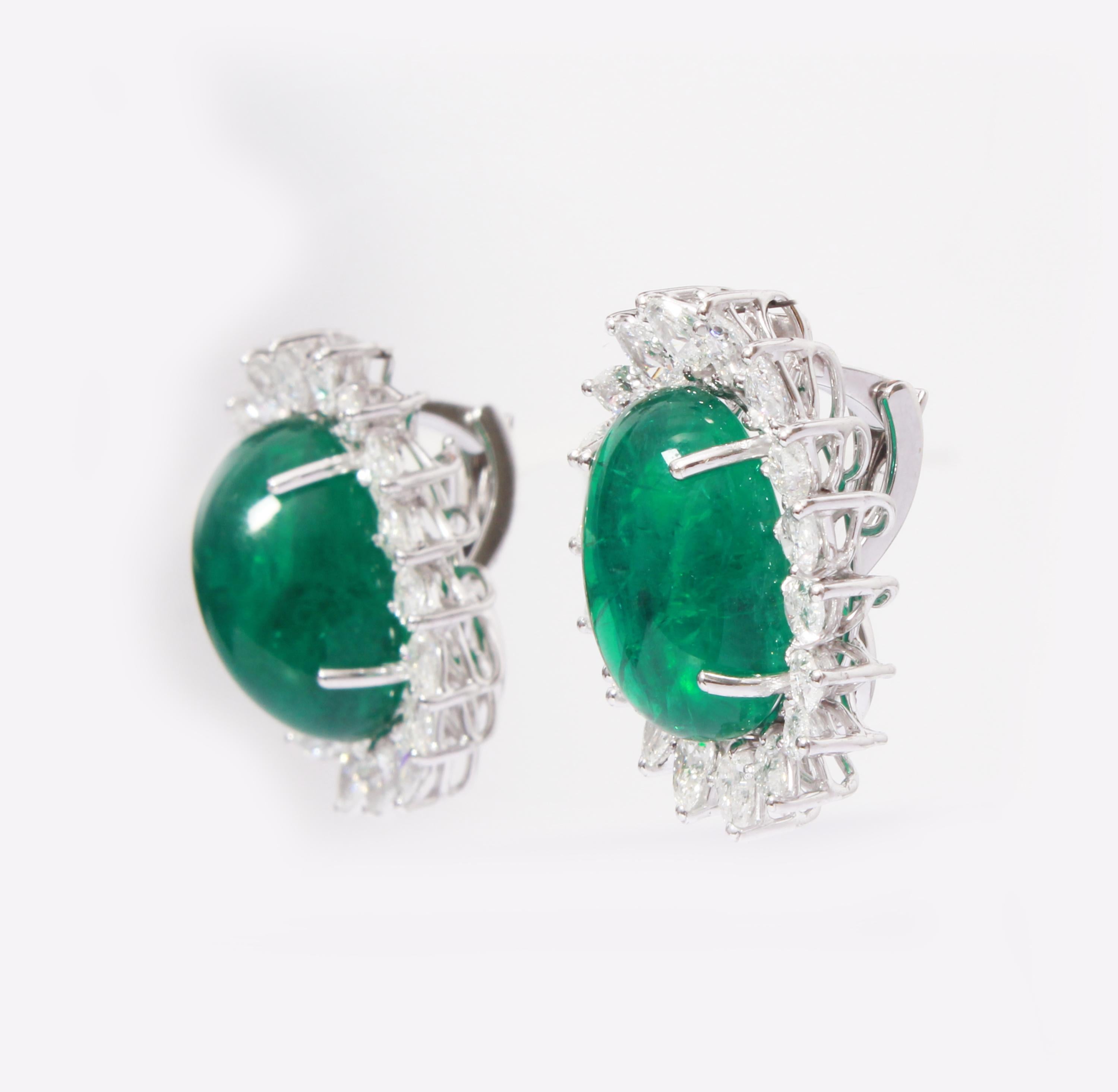 These Earrings have a pair of Zambian cabochon emeralds which weigh 25.02 carats, which are surrounded by 36 Pear Cut White Diamonds that weigh 4.92 carats. The Earrings are made with 18K White gold and weighs approximately 12.270 grams.