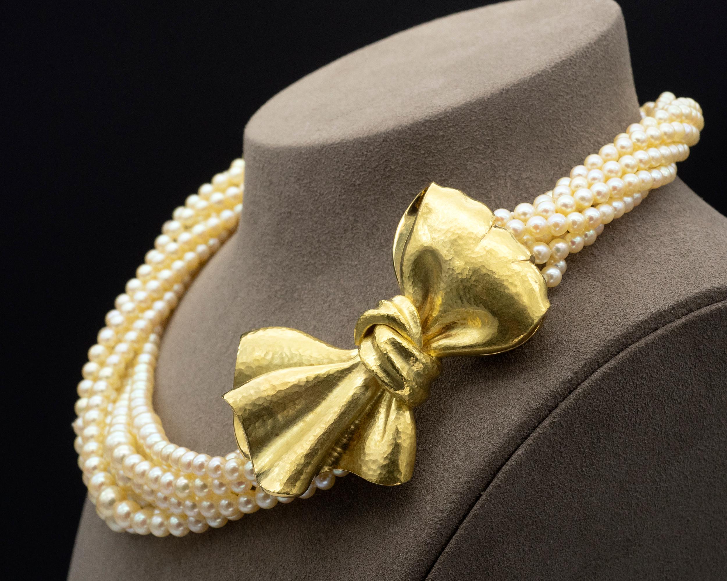 One of a kind multi strand necklace. Seven strands of high lustre Cream colour pearls in a gradient of size (ranging from 3.5 to 7.5mm) are held together by an 18 kt gold hand hammered clasp in a shape of a bow . The make is excellent performed by