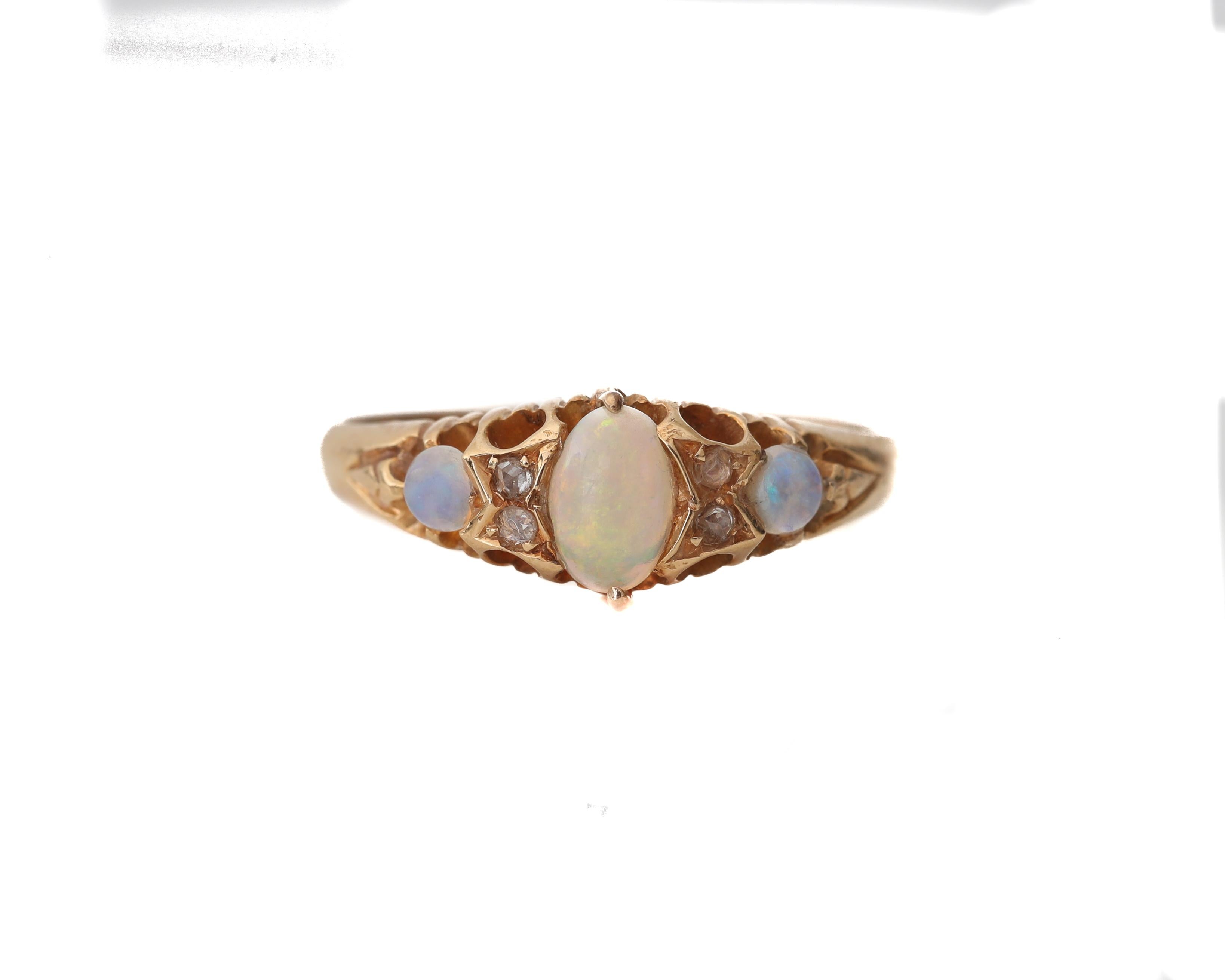 This genuine Victorian beauty is crafted of buttery yellow 18K gold with a large center opal, flanked by diamond rose cuts and two smaller round opals. The shank tapers down from the head towards the shoulder. Center opal is approximately .27 carats