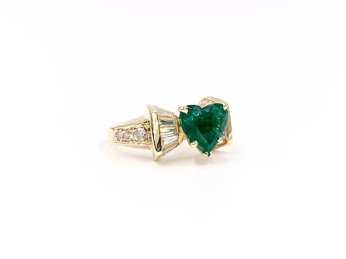 A well saturated, genuine 1.95 carat heart cut emerald is showcased in this polished 18 karat yellow gold baguette and round brilliant diamond setting. Diamond carat total weight is 1.26 carats at approximately H color, VS2 clarity.
Width of ring