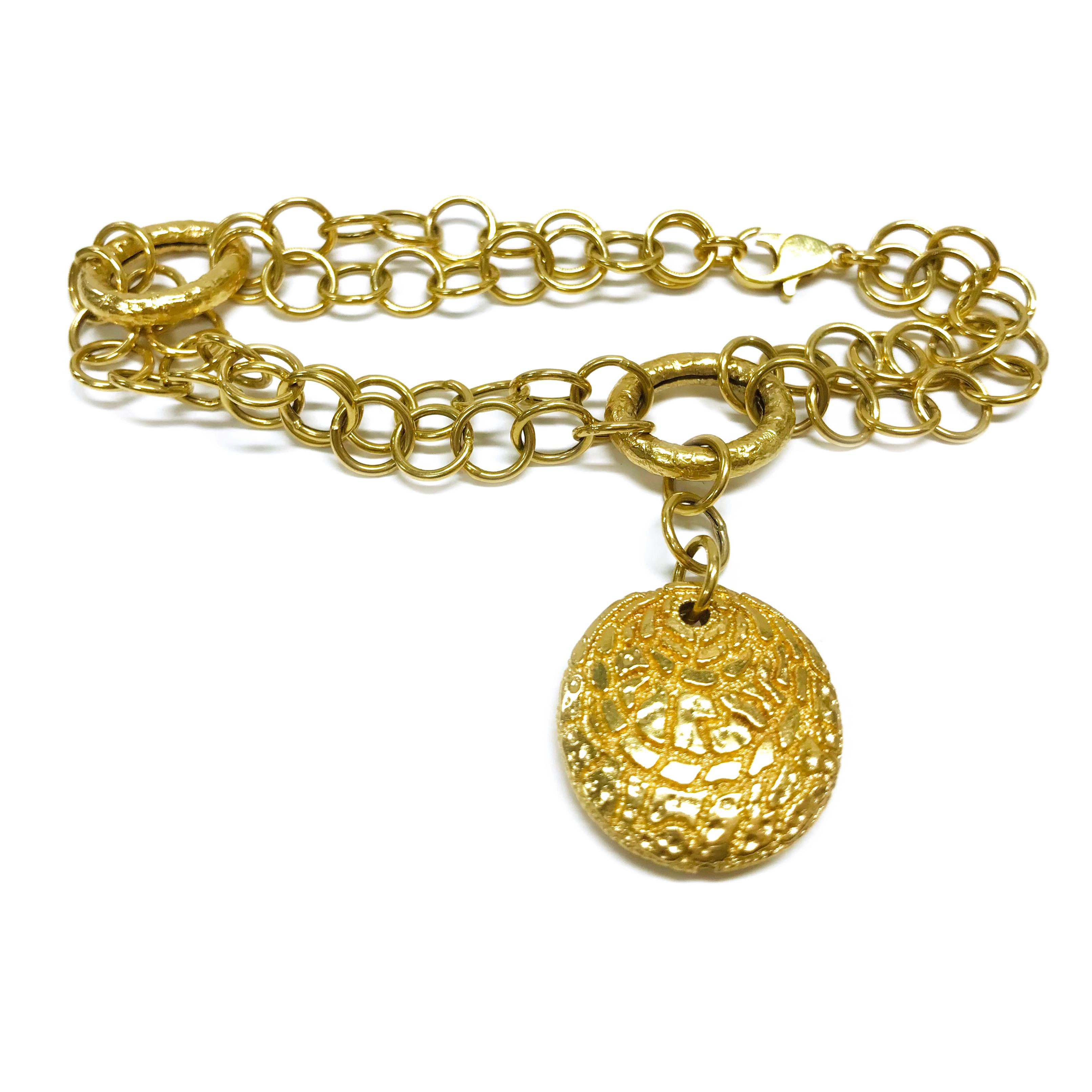18 Karat Italian Charm Link Bracelet. This bracelet features double-round links with two larger hollow oval links and a single disc shaped charm. The hollow disc charm has a nugget texture and is approximately 0.79