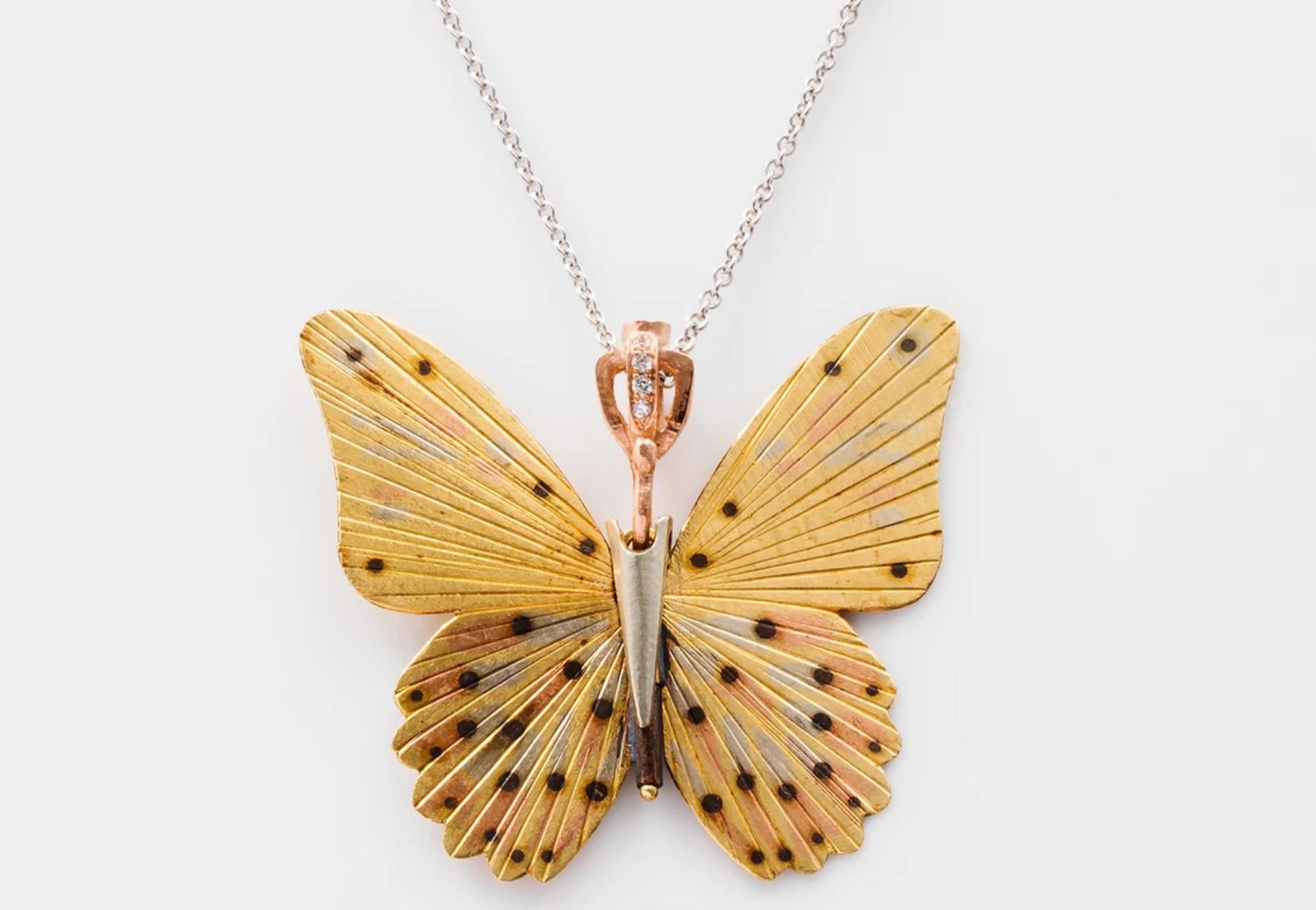 James Banks's signature butterfly necklace features a Large Troides Helena species Butterfly with a hinge at the center to allow movement of the wings, set in 18k Yellow Gold, 14k Rose Gold, 18k White Gold, Copper, and Sterling Silver inlay, hung on