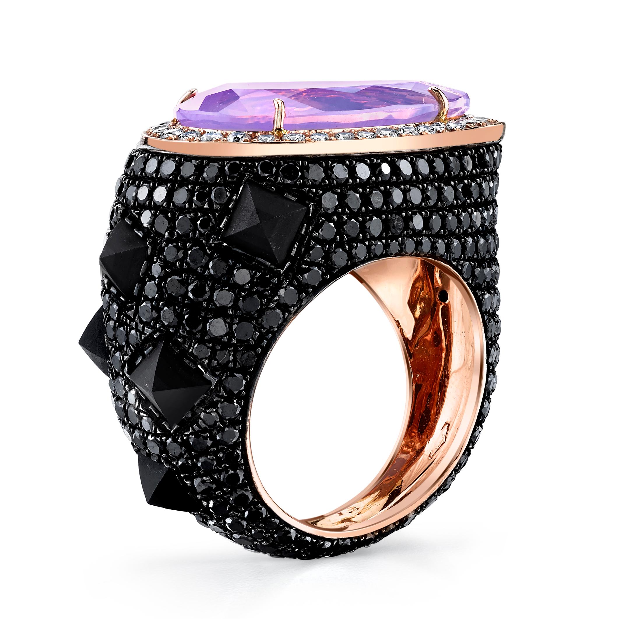 Mystical Lavender Moon Quartz and Black Diamond Spike Cocktail Rock Ring 
features a Pear Cut Lavender Moon Quartz displaying hues of pink and violet, framed in White Diamonds and Rose Gold, wrapped in Black Diamond Pave with accents of inverted