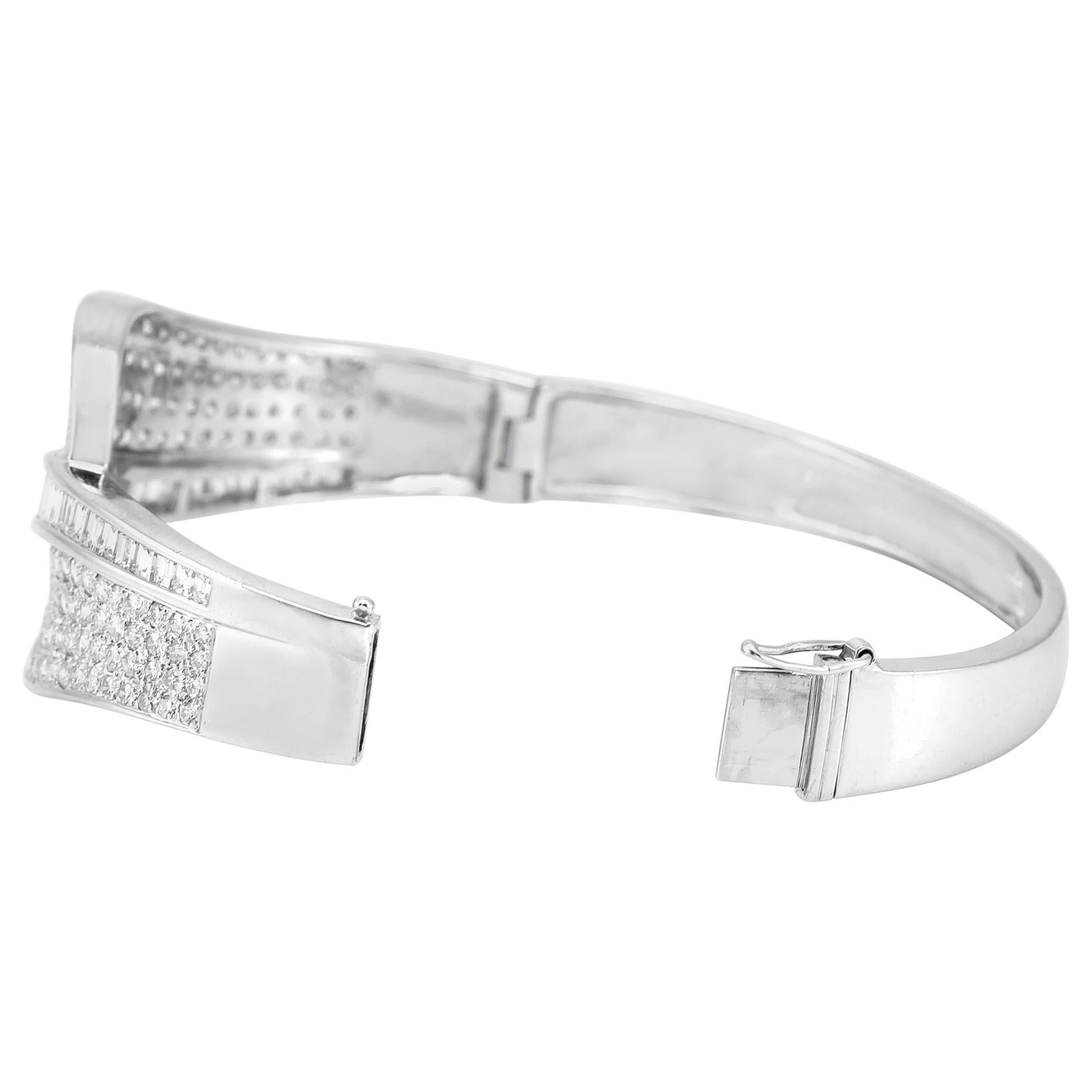 This bangle is finely crafted in 18K white gold. 
The diamonds are emerald cut and round brilliant, weighing an approximate total of 11.23 carat.
Circa 2000