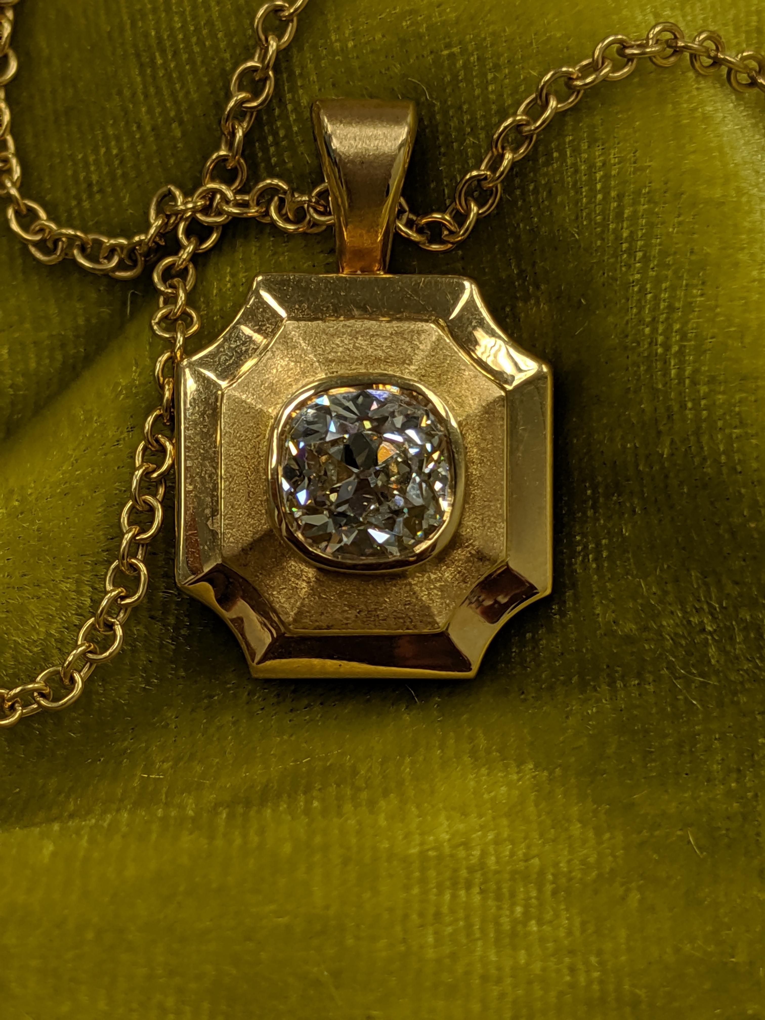This modern classic combining a handmade locket in high karat gold with a larger Antique Cut Cushion Diamond is rare in the marketplace.  Uniquely online with 1stDibs, this Locket made by E.A. Guild features a two carat cushion cut diamond.  The