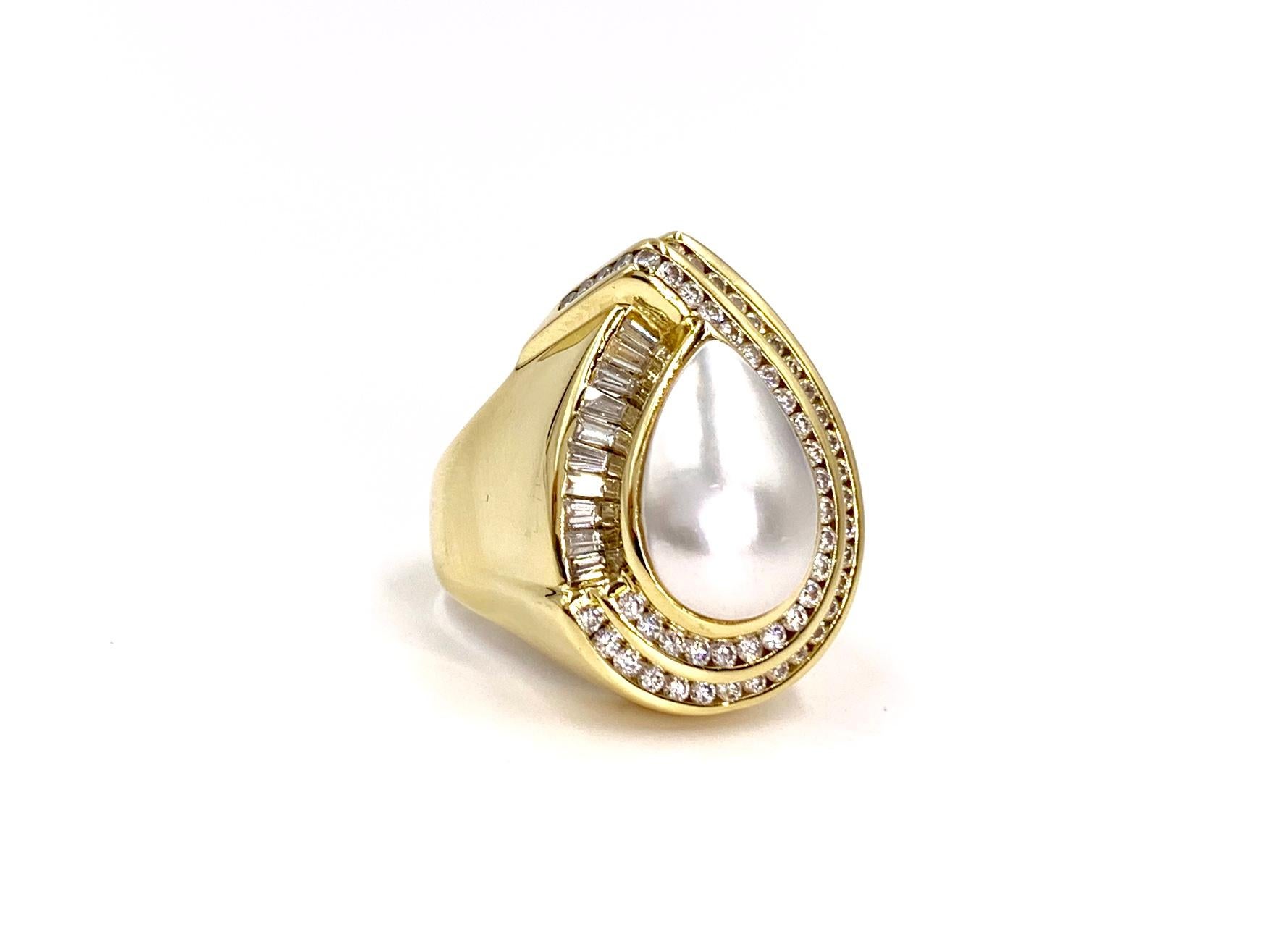 A true statement piece, expertly crafted by Charles Krypell. This 18 karat yellow gold cocktail ring features a large lustrous genuine pear shape mabe pearl surrounded by .98 carats of round brilliant and baguette cut diamonds. Diamond quality is