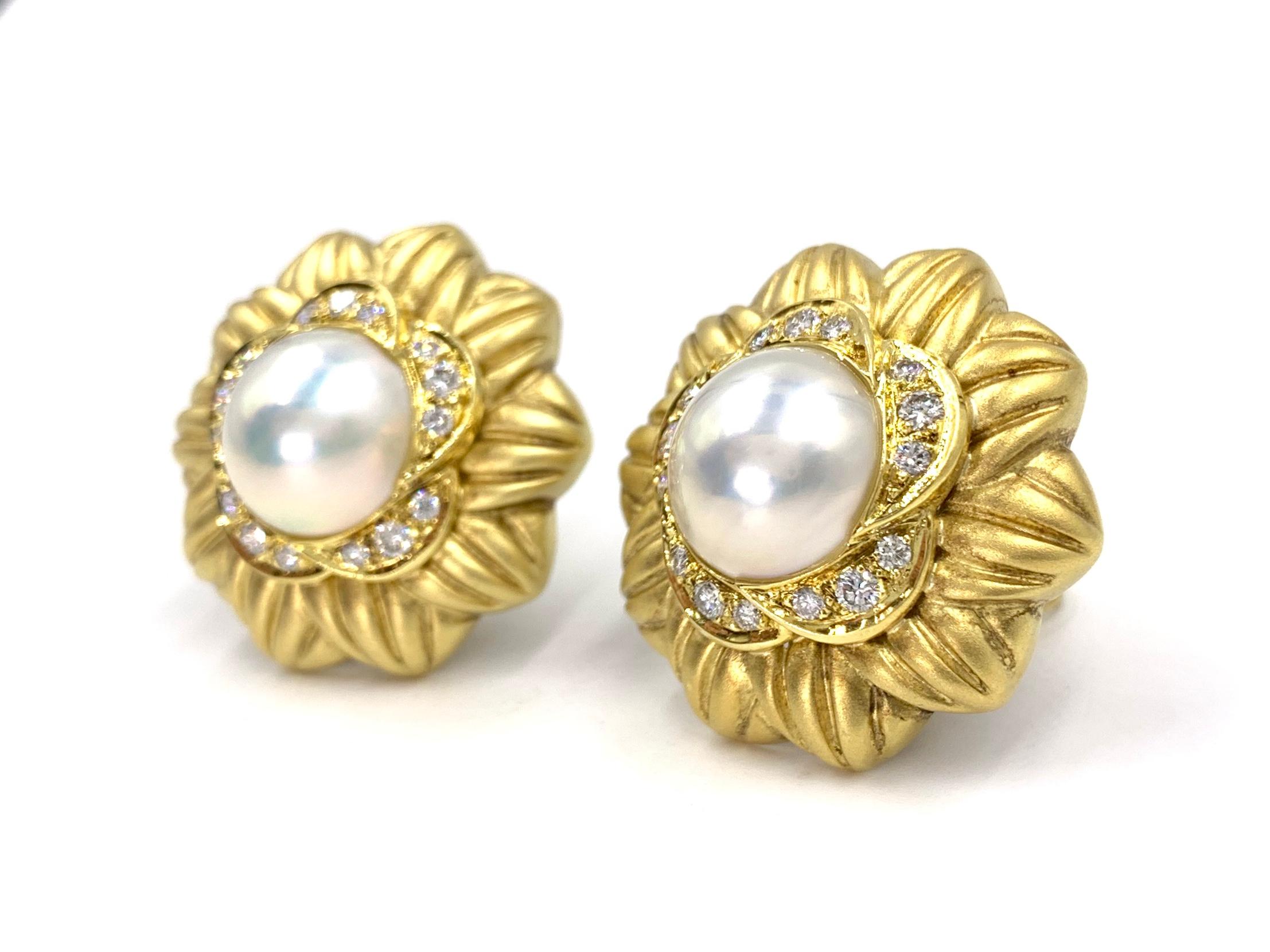 Sophisticated and beautiful acid washed 18 karat yellow gold large floral shaped button style earrings feature 1 carat of round brilliant diamonds and 13mm lustrous cultured mabe pearls. Diamond quality is approximately F color, VS1 clarity. The
