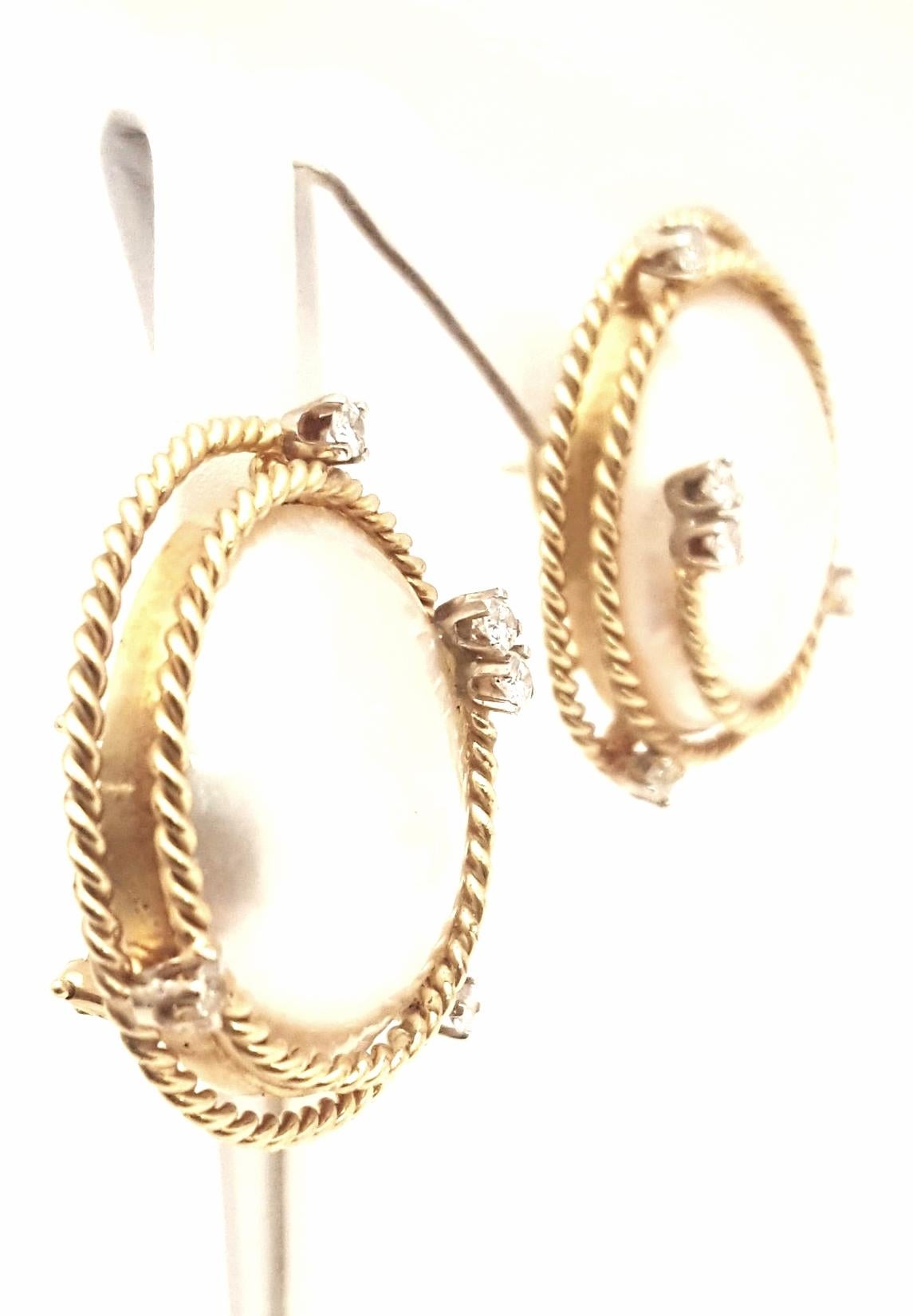 These fabulous Mabe pearl earrings will never be out of style or dated.  Beginning with bezel set round Mabe Pearl measuring an impressive 23mm!  Beautifully accented by 18 karat yellow gold rope borders boasting five brilliant cut diamonds on each