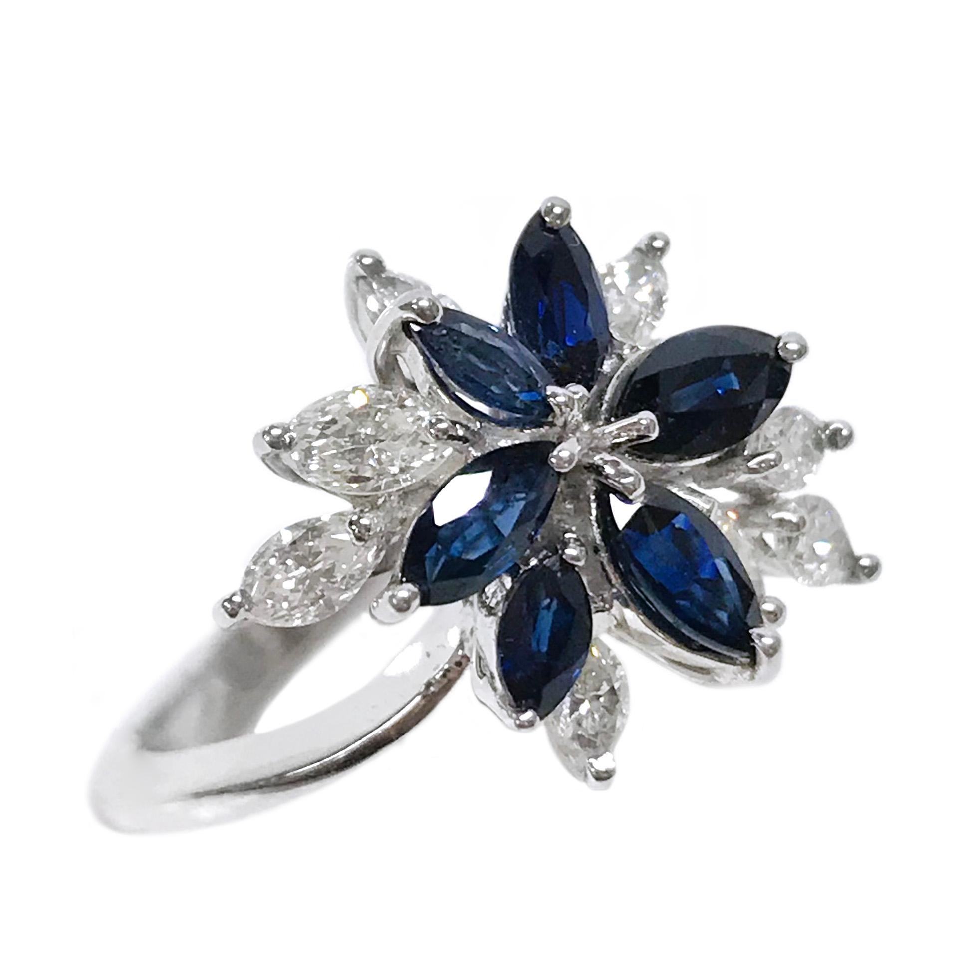 18 Karat Marquise-Cut Blue Sapphire Diamond Cluster Ring. The ring band tapers slightly being thicker at the bottom. The cluster ring features six marquise-cut blue sapphires and eight marquise diamonds, all stones are prong-set in white gold. The