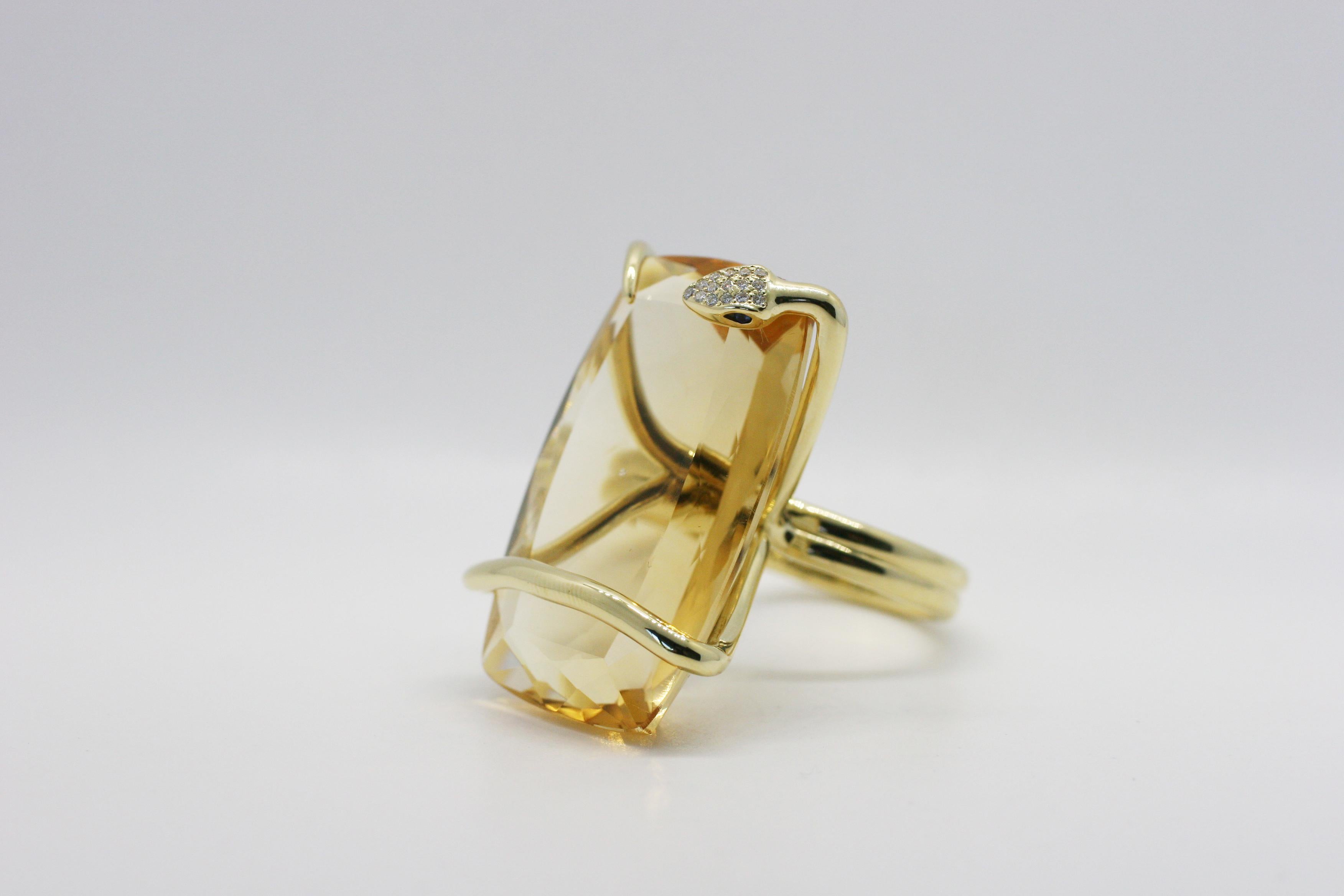 18k Yellow Gold Citrine Climbing Snake Ring features Perez Bitan's signature curved snake with blue sapphire eyes and white diamond micro pave head that wraps around the finger and sets the cushion cut large natural citrine in place 
18k Yellow