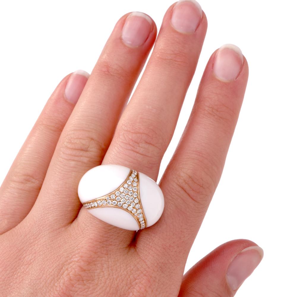 This opulent bombe design cocktail ring is crafted in 18 karat yellow gold, weighing 19.1 grams and measuring 20 mm wide and 15 mm high. The large domed plaque is rendered in artfully carved white coral, embellished with a diamond-set triangular