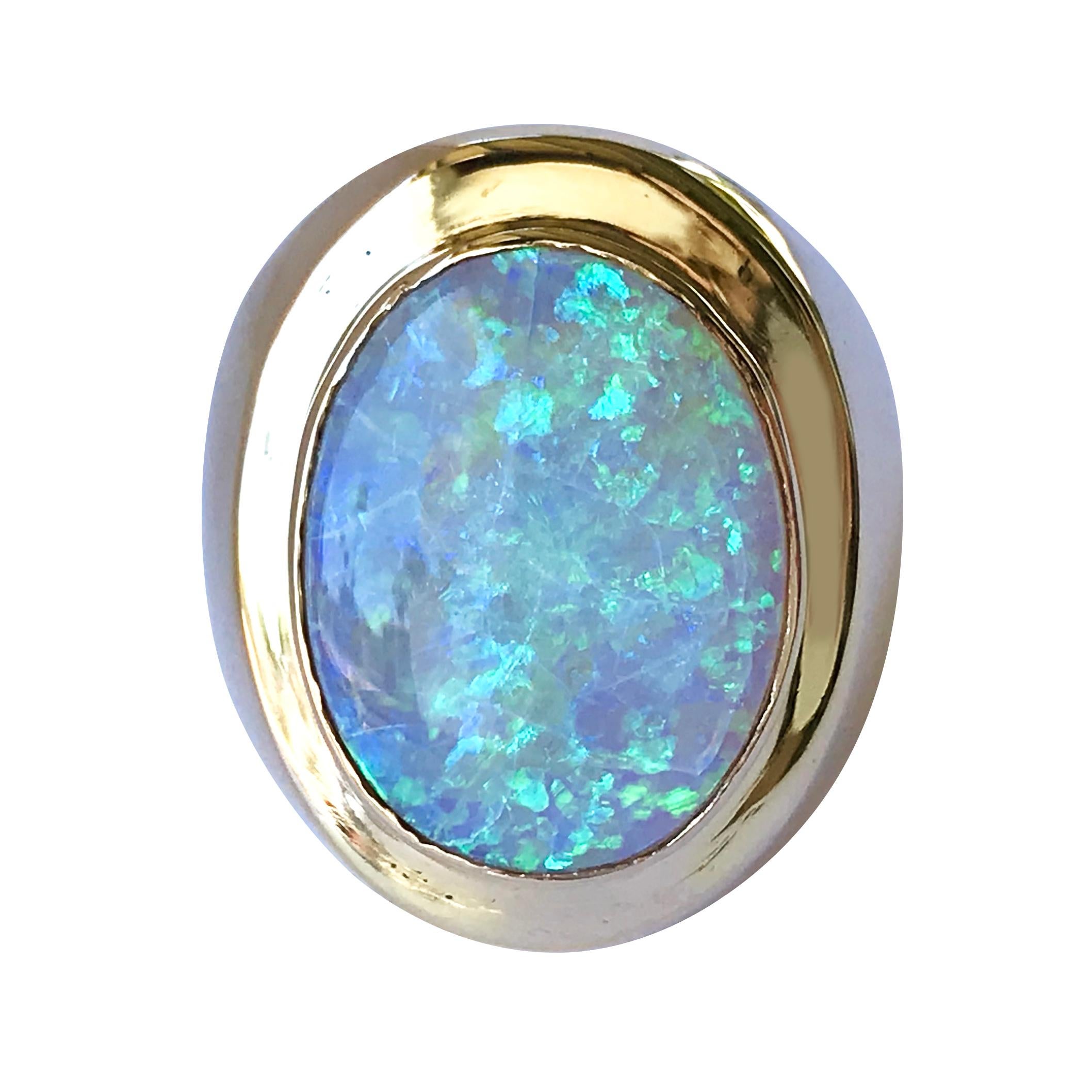 18 Karat Oval Opal Ring. The ring features an oval Opal and wideband that tapers. The Opal measures 17.8mm x 13.55mm x 5.6mm and has a carat weight of 6.96ct. The color of the rainbow, the glow of the Northern Lights, the dramatic flash of summer