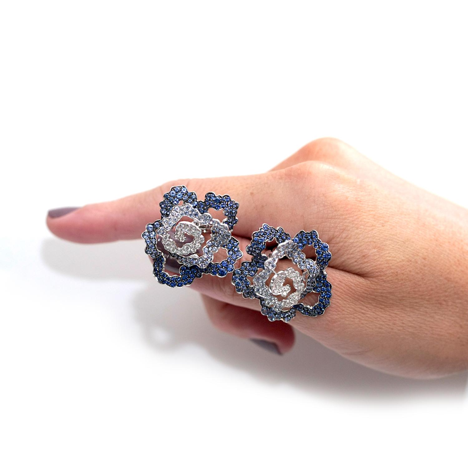 Designed by Italian designer Palmiero, these earrings feature a flower shape, paved with full-cut diamonds and blue sapphires of different shades of blue (from royal strong blue to very light blue). 
White 18k Gold 
Weight: 12.20 Grams
White