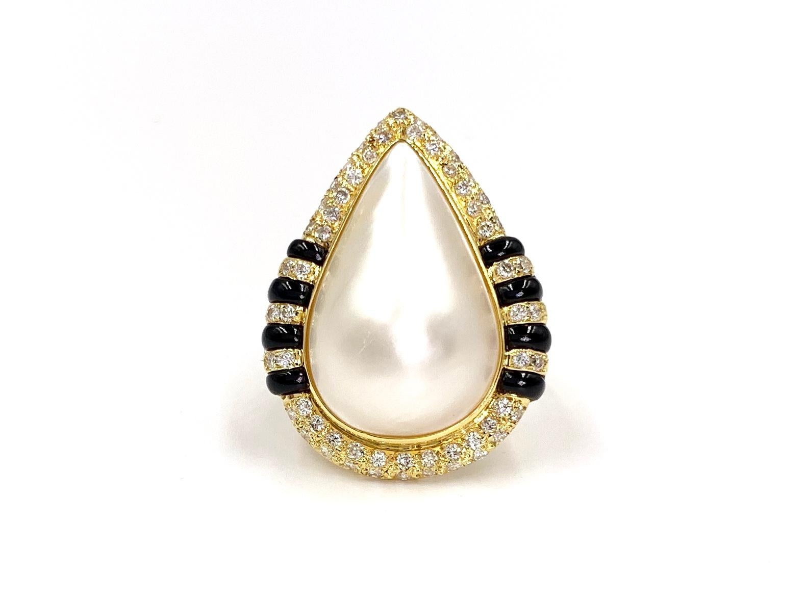 A modern design with a touch of Art Deco influence. This 18 karat yellow gold cocktail ring features a pear shape cultured pearl surrounded by .74 carats of expertly pavé set white diamonds and 8 pieces of polished black jade. Diamond quality is