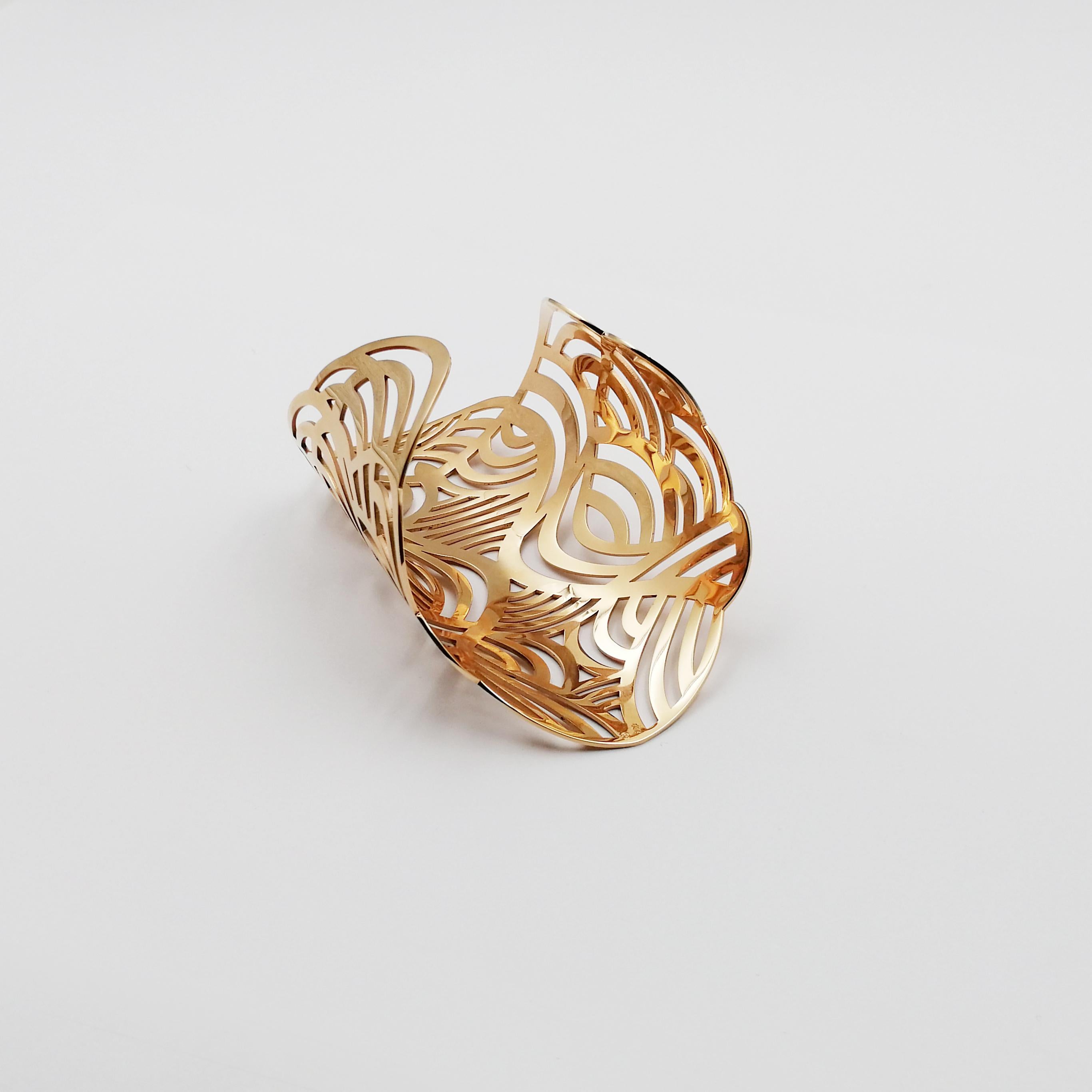 Widespread yet delicate, the fine lines of 18 karat pink gold forming this remarkable arm cuff wrap around the wrist with ease. In hypnotizing symmetry, the golden trails wind in bows and arches, giving the structure a tribal appeal. The bent shape