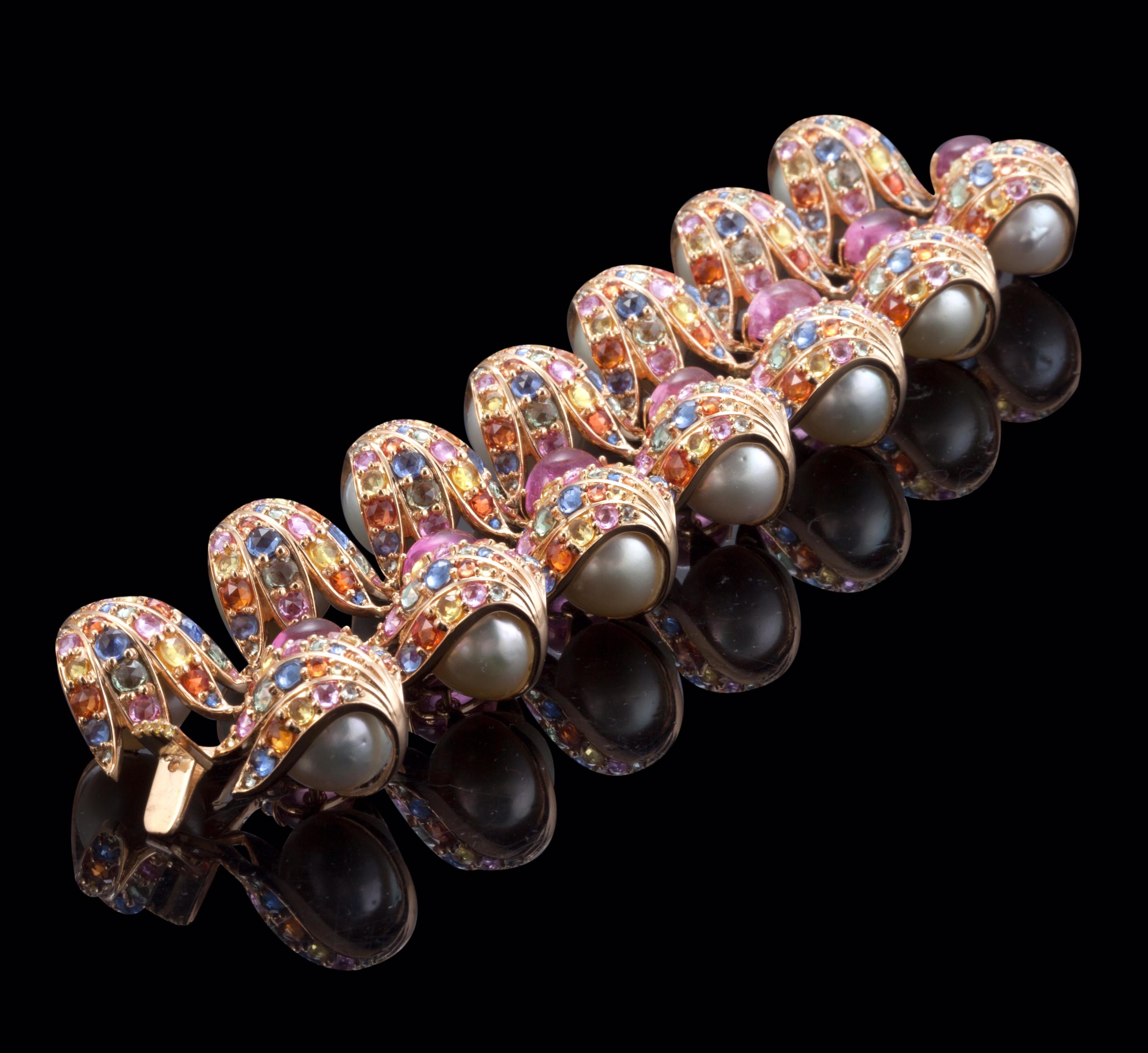 The magnificent fan vaulting of the great Cloister & the amazing stained glass work of the Gloucester Cathedral (England) are at the soul of the magnificent bracelet in 18K gold finished off with enormous south sea pearls

Material: 18K gold
Pink