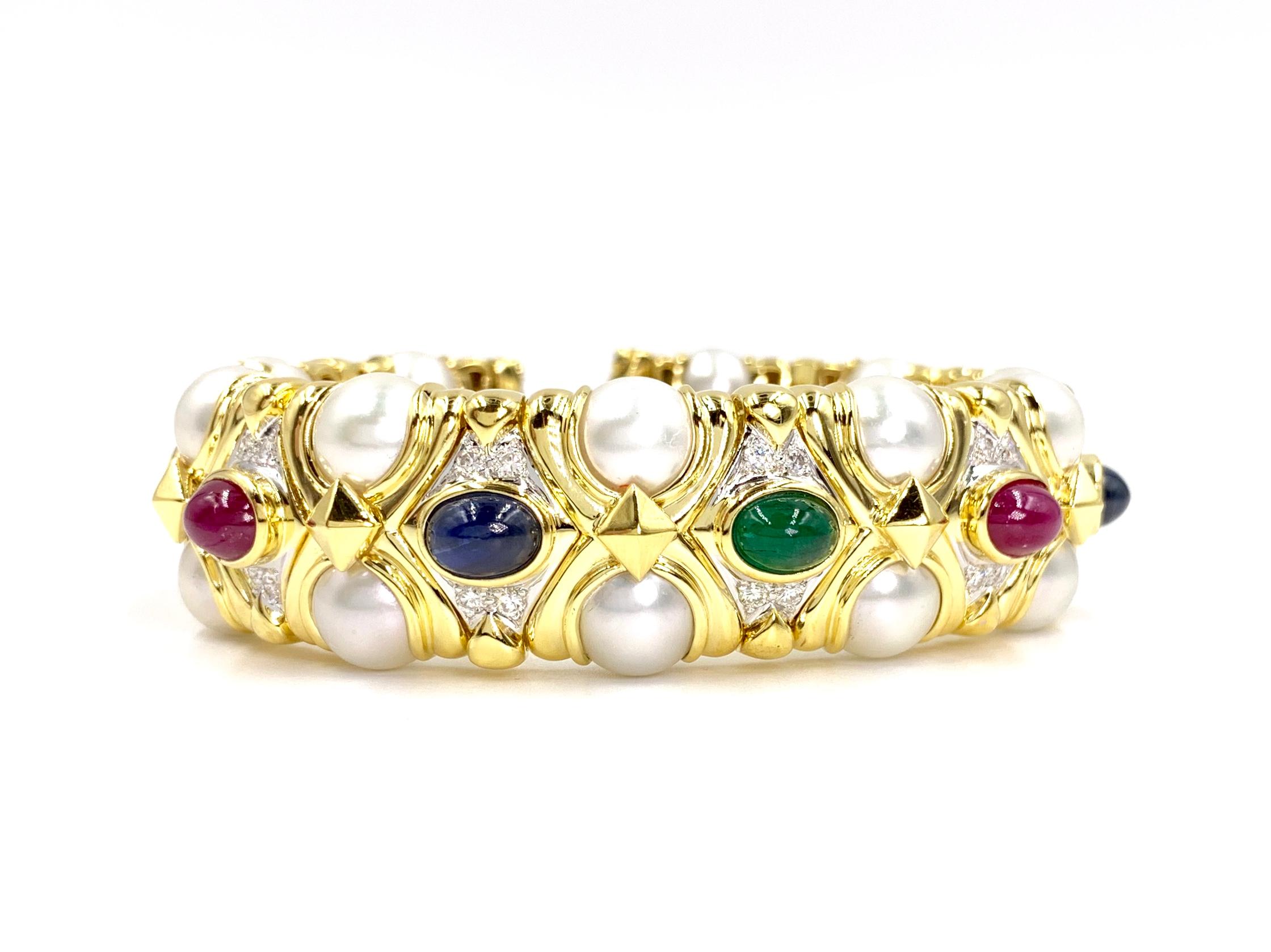 Incredibly crafted in 18 karat yellow gold, this cuff bracelet features lustrous cultured pearls, rubies, blue sapphires, diamonds and a single emerald. Oval cabochon precious gemstones are well saturated. Diamond quality is approximately G color,