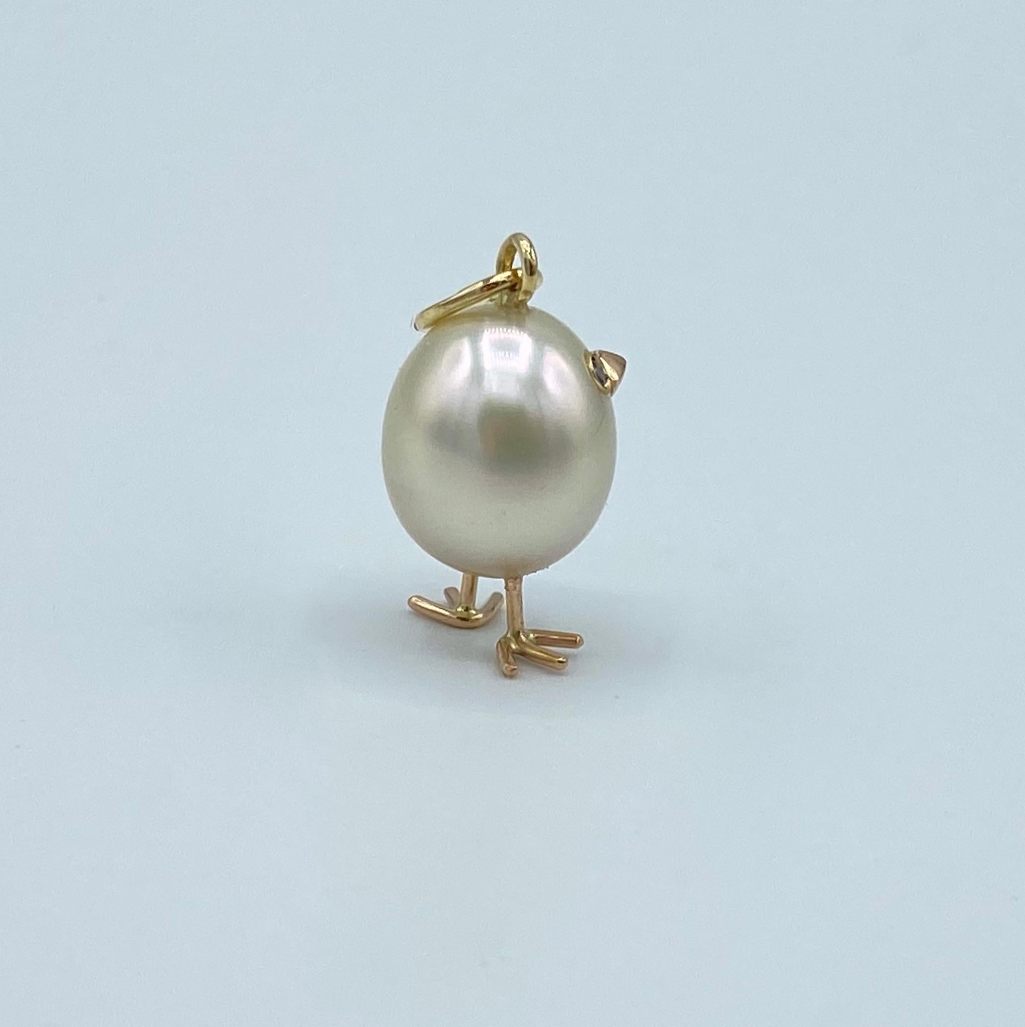 Chick Australian Pearl Diamond Yellow Red white 18 Kt Gold Pendant or Necklace
A oval shape Australian pearl has been carefully crafted to make a chick. He has his two legs, two eyes encrusted with two black diamonds and his beak. 
The gold is red