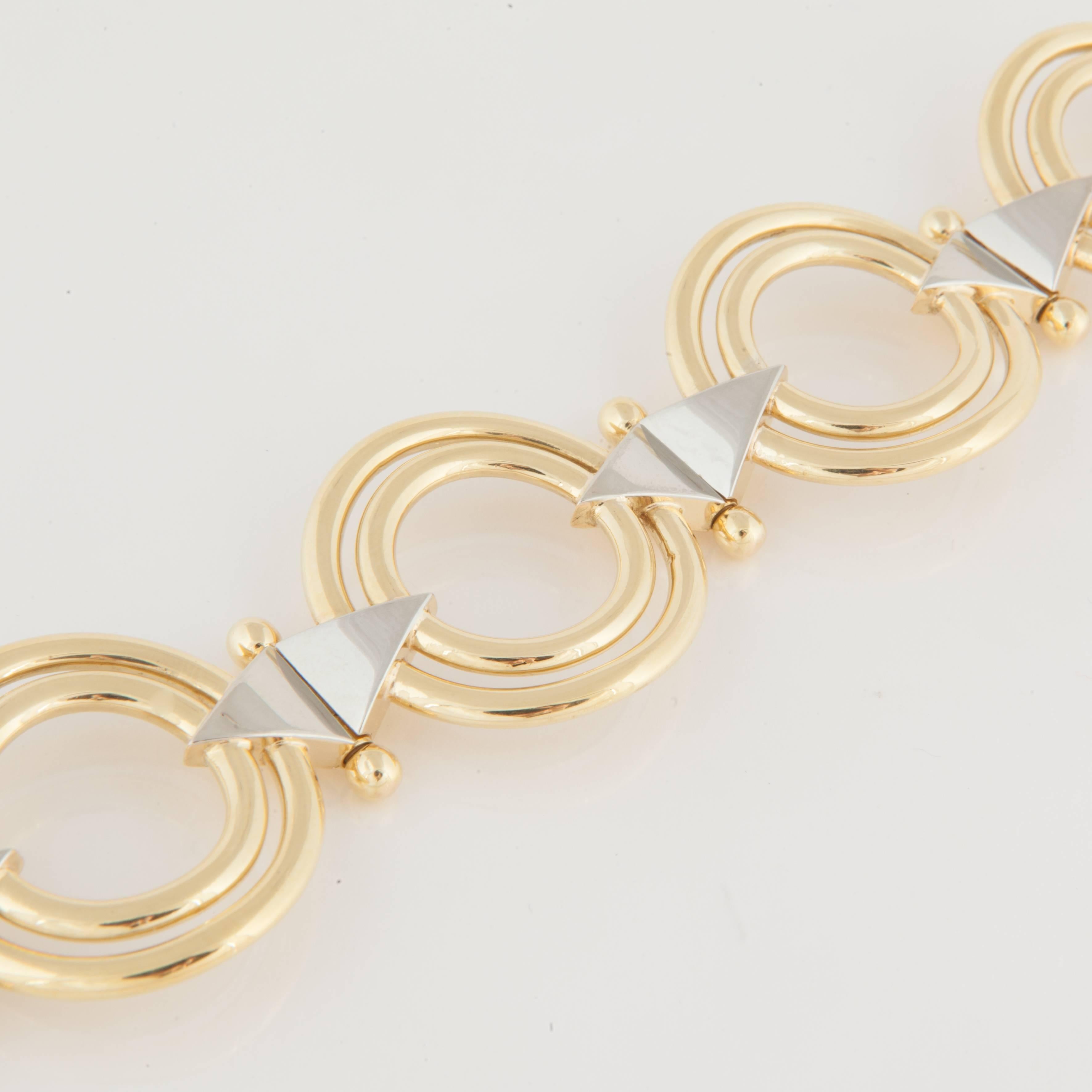 Retro bracelet in 18K yellow and white gold, comprised of concentric circles with hinged triangle links.  Measures 7 inches long and 1 1/8 inches wide.  Circa 1940-1950.