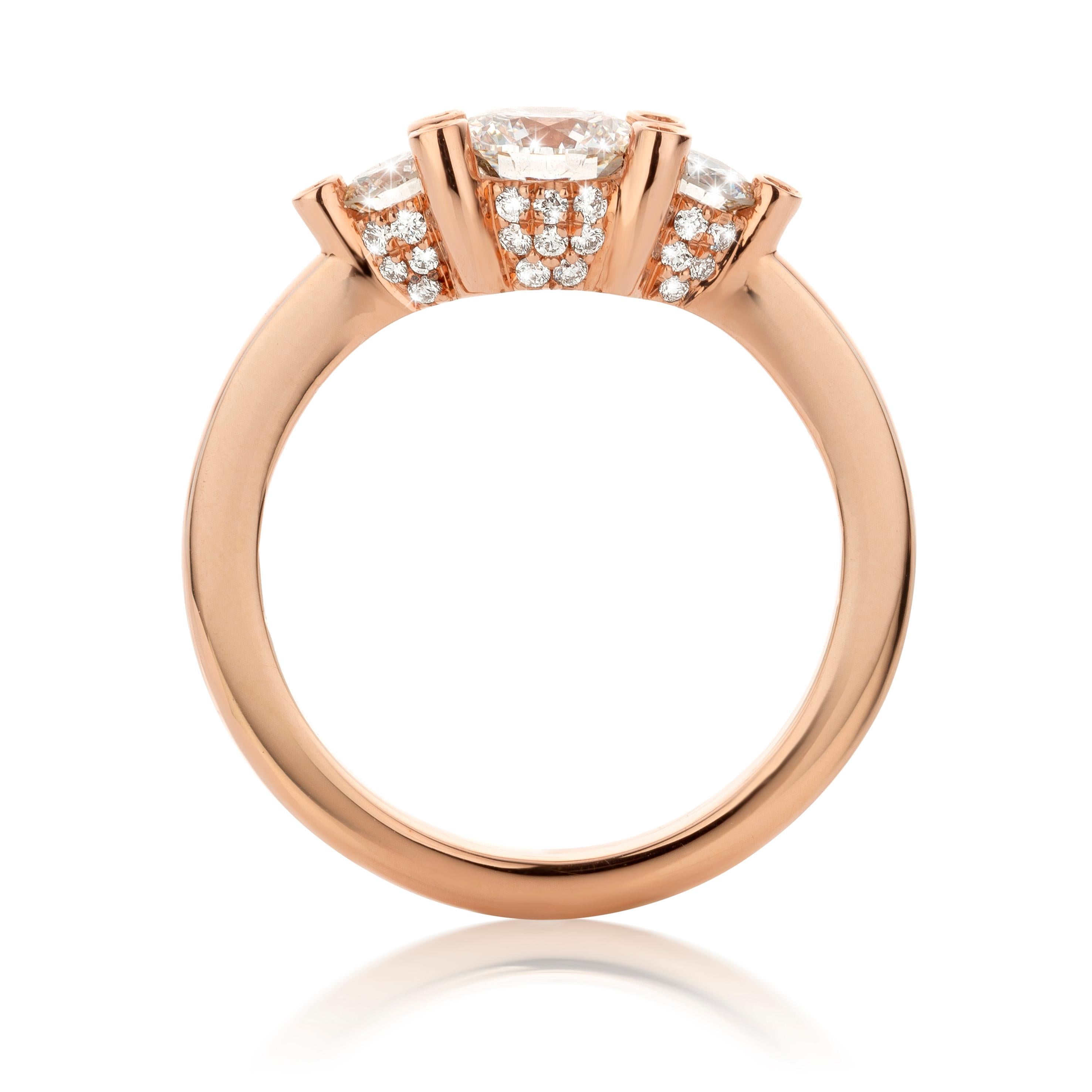 Handmade Three-stone ring in 18K Rose gold 5,6 g. set with a 0,71 carat FSI1 brilliant-cut diamond centerstone and 2 X  0,15 carat FGVS brilliant-cut diamonds:  0,30 carat., 36 X small FGVS brilliant-cut diamonds on the side : 0,17 ct.  Total carat