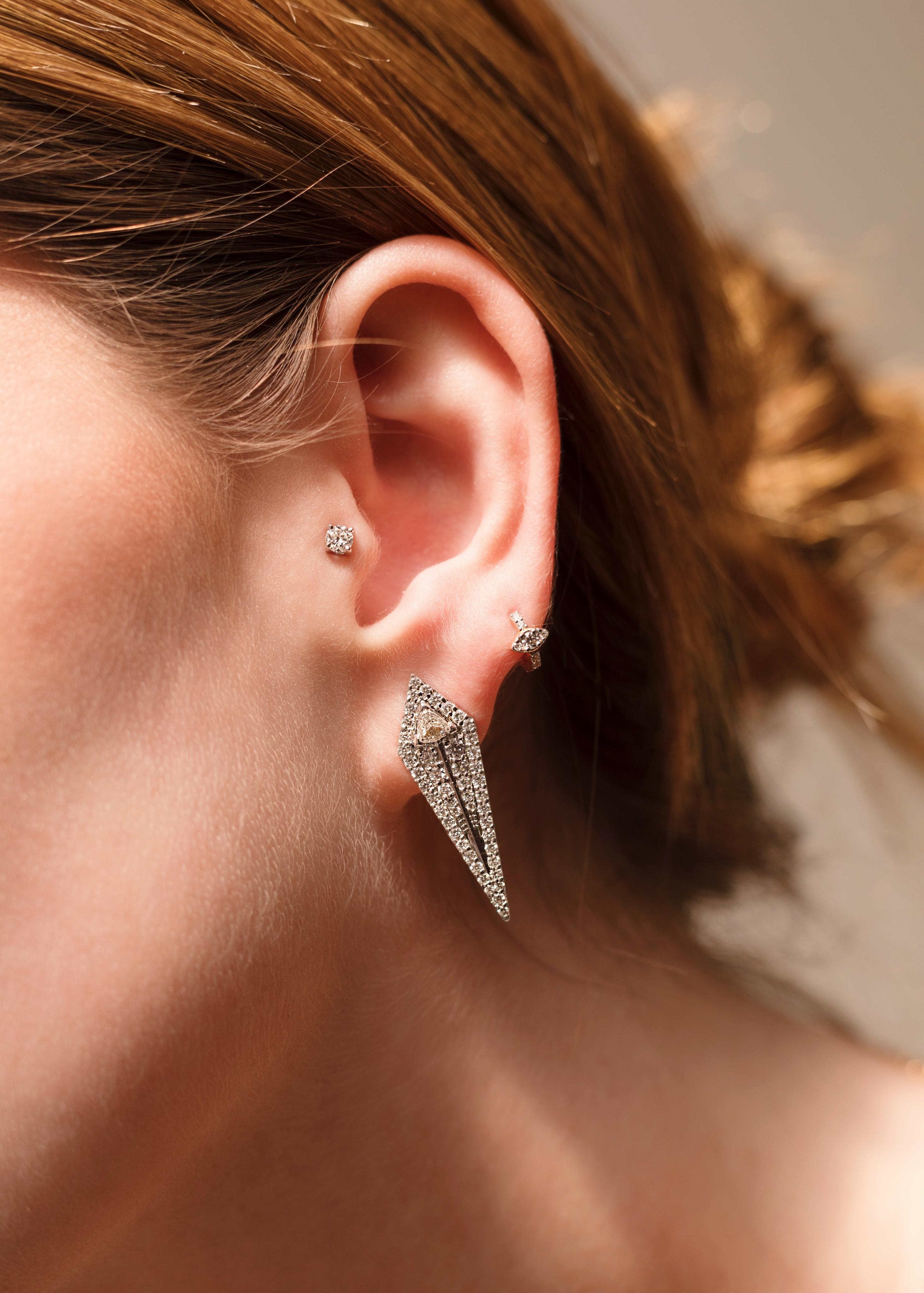 A fascinating take on antique jewelry design, this pair of pierced earrings is at once classic and modern. The arrow motif features a lavish palette of handsome glossy colourless diamonds with intriguing matrix and symbolises pure fierce. Feminine